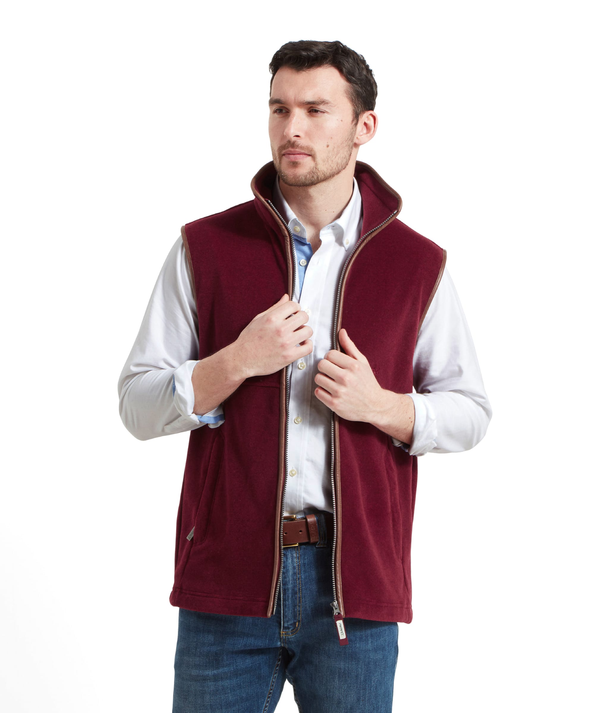 A man models the Schöffel Oakham Fleece Gilet for Men in Red, showing the front view of the gilet with his hands adjusting the zipper.