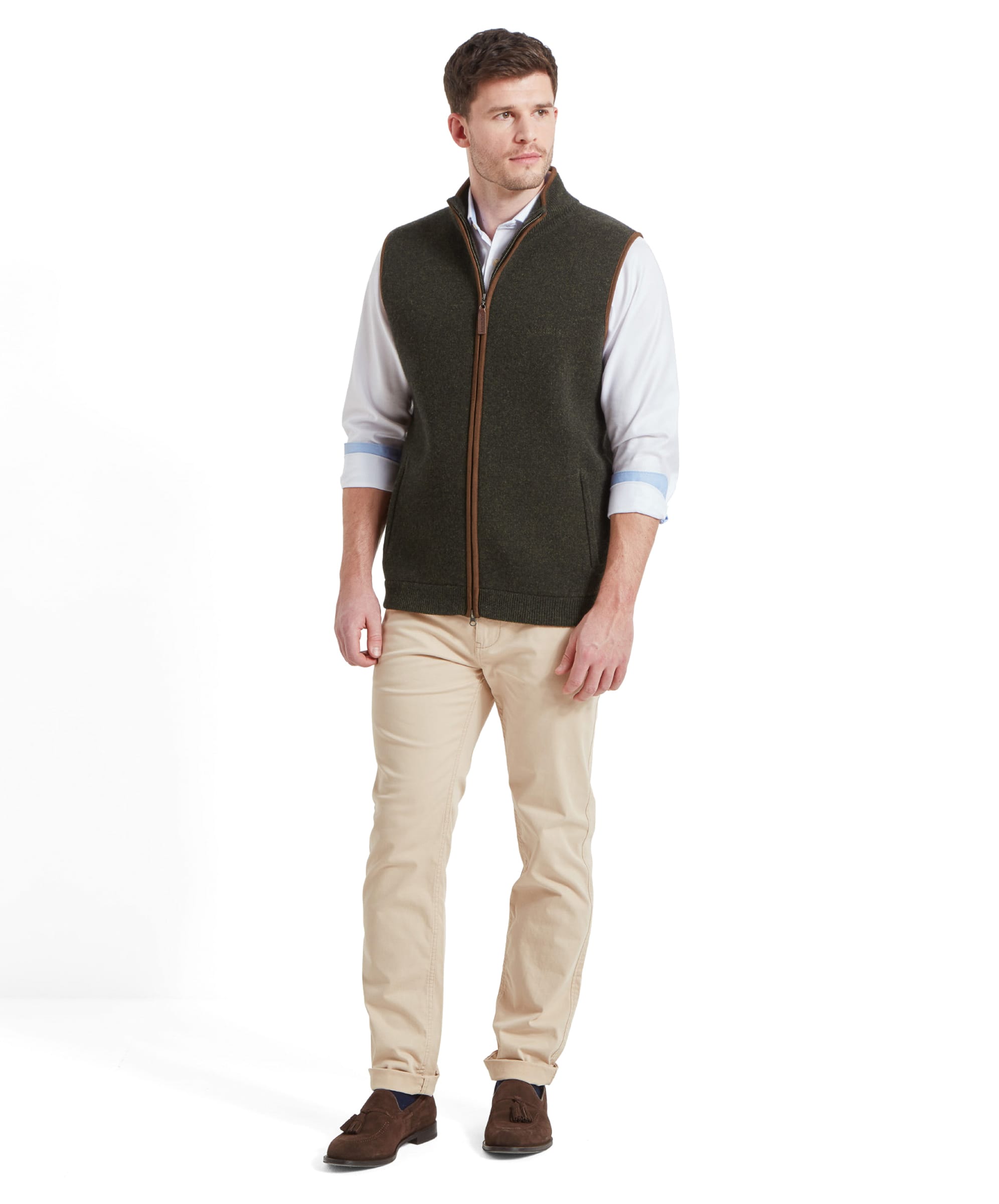 A full-body image of the man wearing the Schöffel Orkney Merino Gilet for Men in Green, standing straight with a relaxed pose.