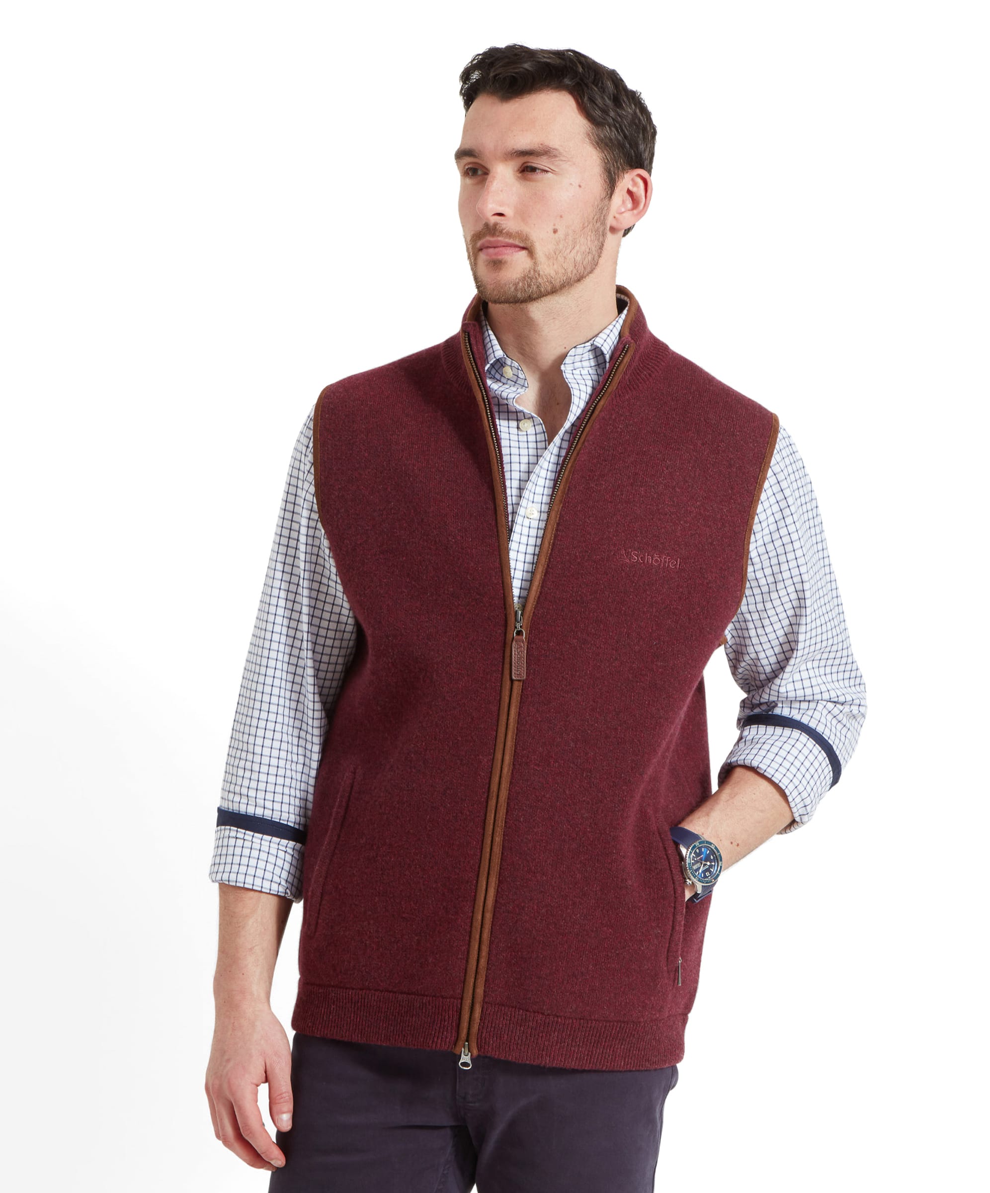 A man wearing the Schöffel Orkney Merino Gilet for Men in Red, standing confidently with hands in his pockets.