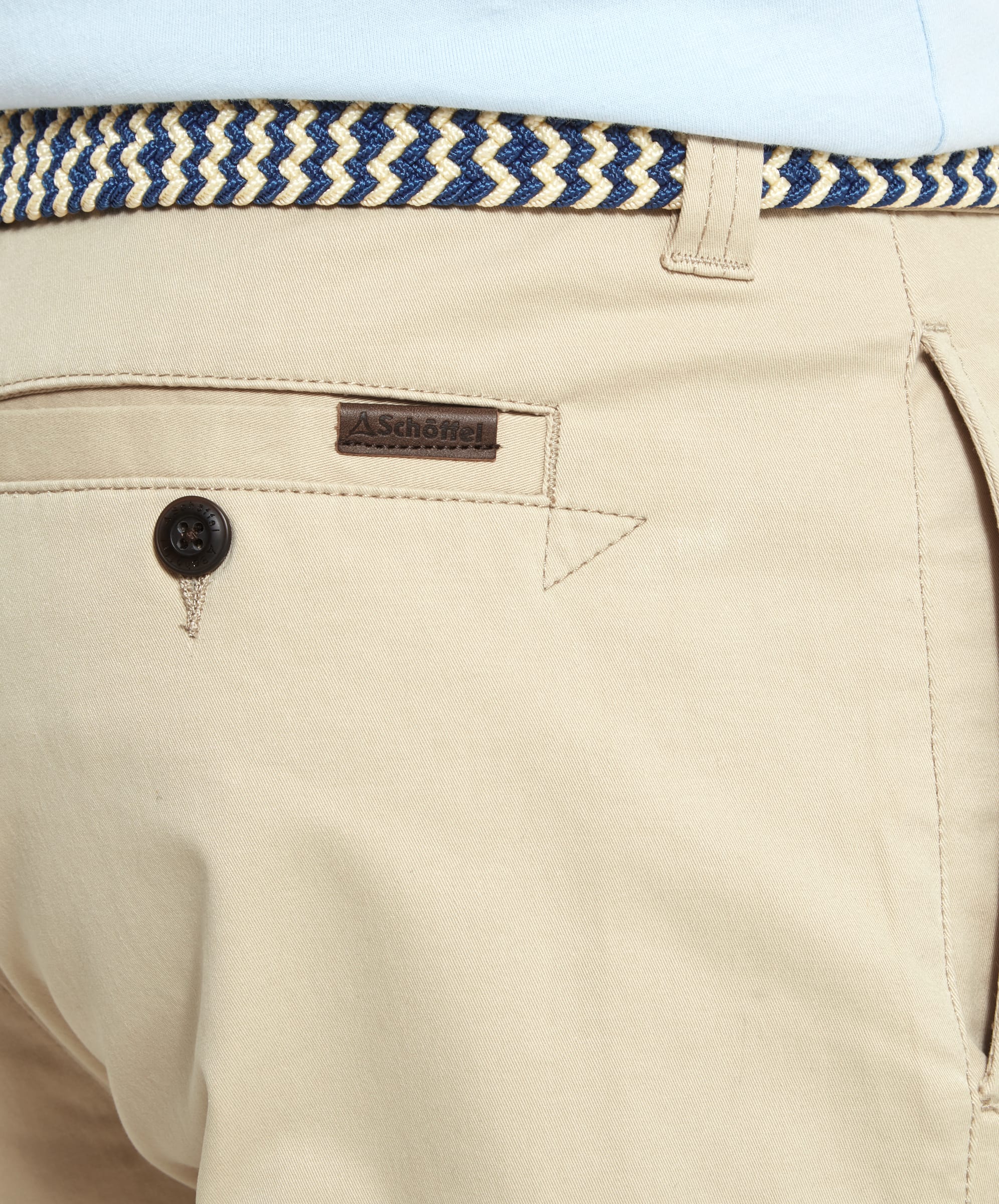 Close-up image of the back pocket of Schöffel Paul Shorts for Men in Beige, showing the Schöffel logo and button detail.