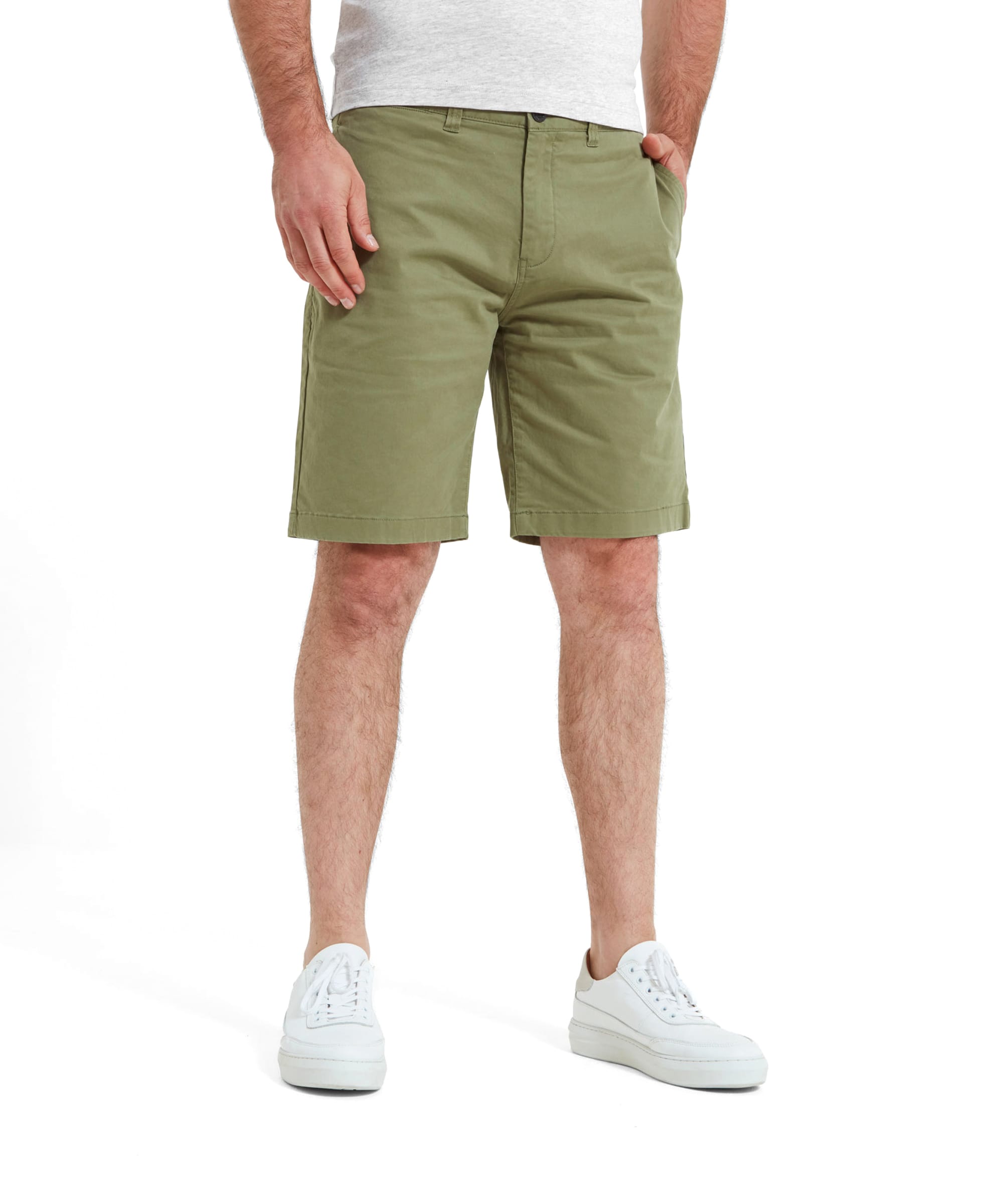 A model wears the Schöffel Paul Shorts for Men in Green, showcasing the front view. The shorts are paired with a simple white t-shirt and white sneakers, emphasizing their casual and comfortable style.