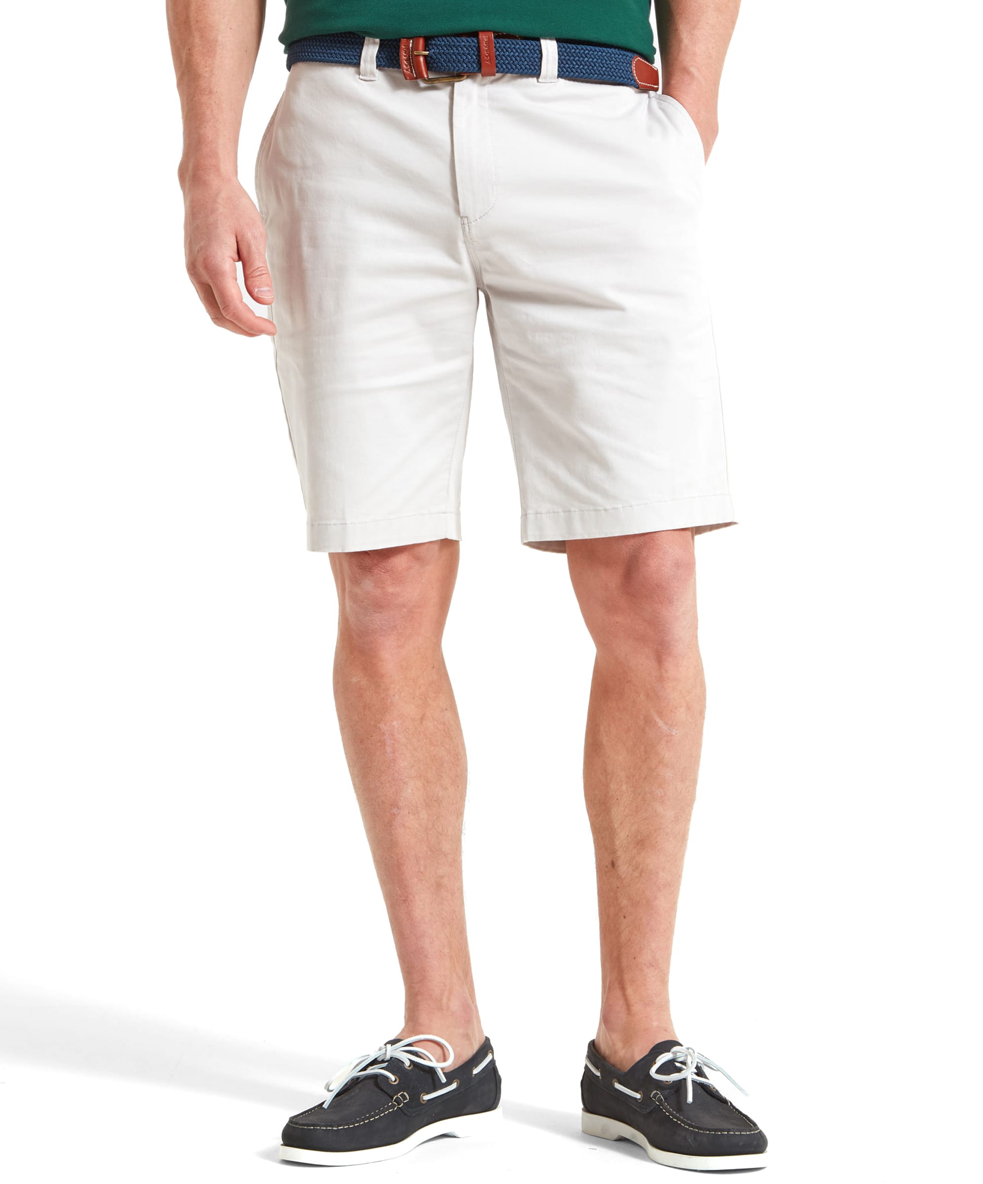 A man wearing Schöffel Paul Shorts for Men in Light Grey, paired with a belt and boat shoes, standing with one hand in the pocket.