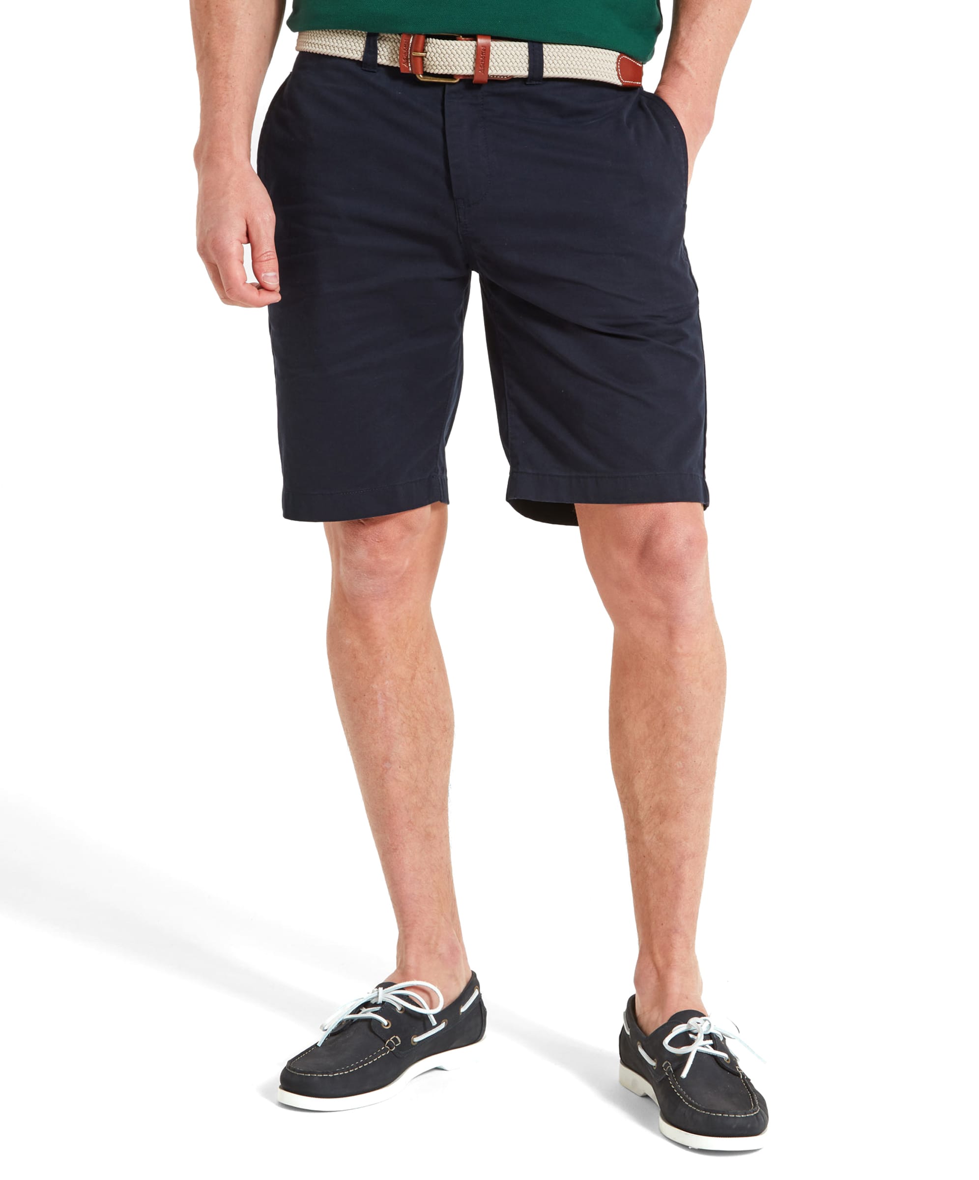 A model wears the Schöffel Paul Shorts for Men in Navy, paired with boat shoes and a green polo shirt, showcasing a casual summer look.