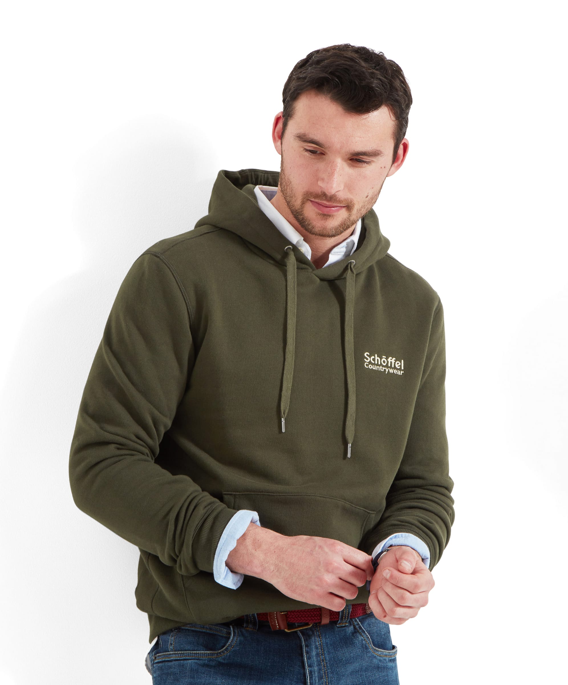 A man wearing Schöffel Pentire Heritage Hoodie for Men in Green, standing with his hands adjusting the sleeves.