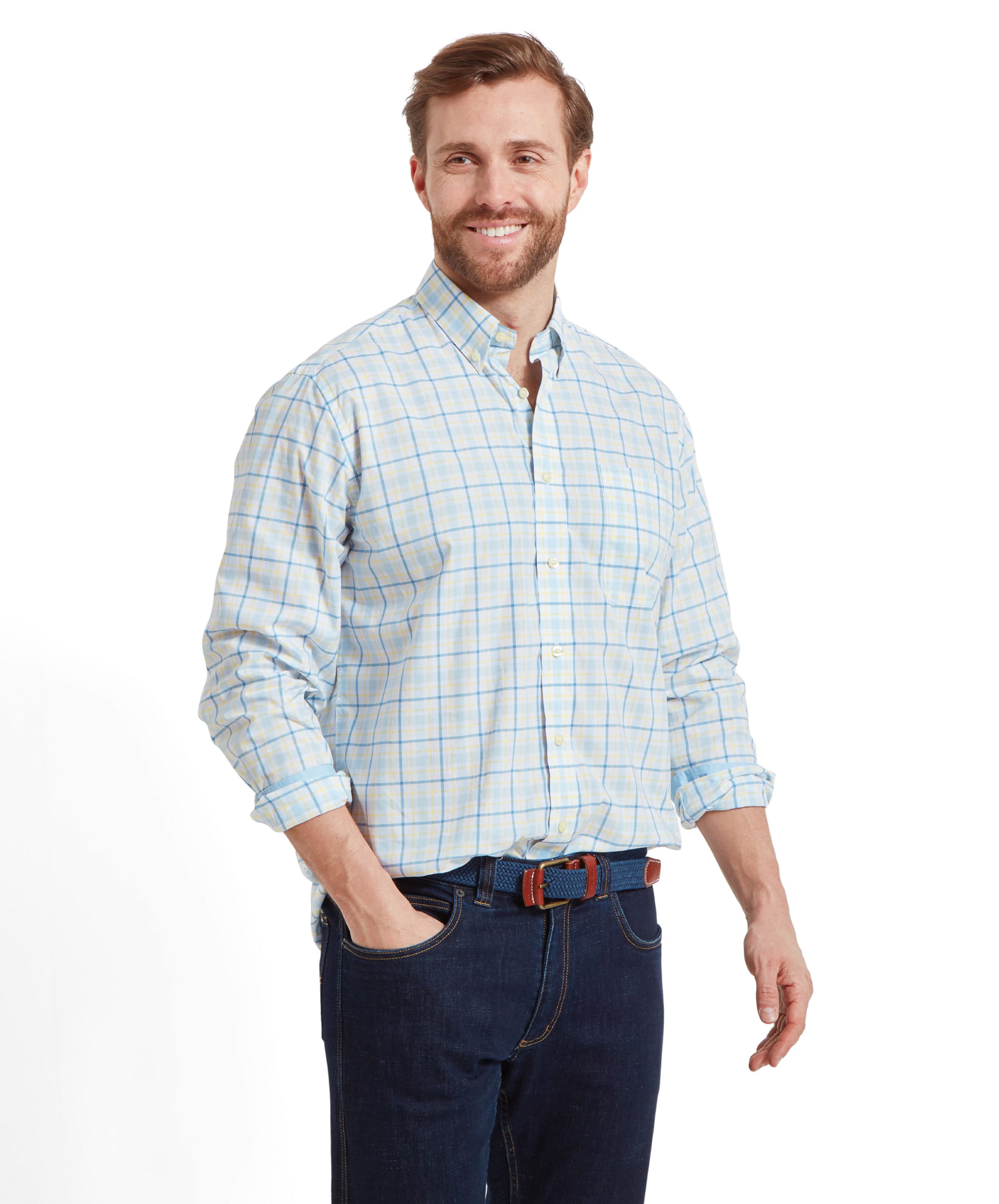 A man modeling the Schöffel Polstead Classic Shirt for Men in Blue and Yellow, smiling and standing with one hand in his pocket.