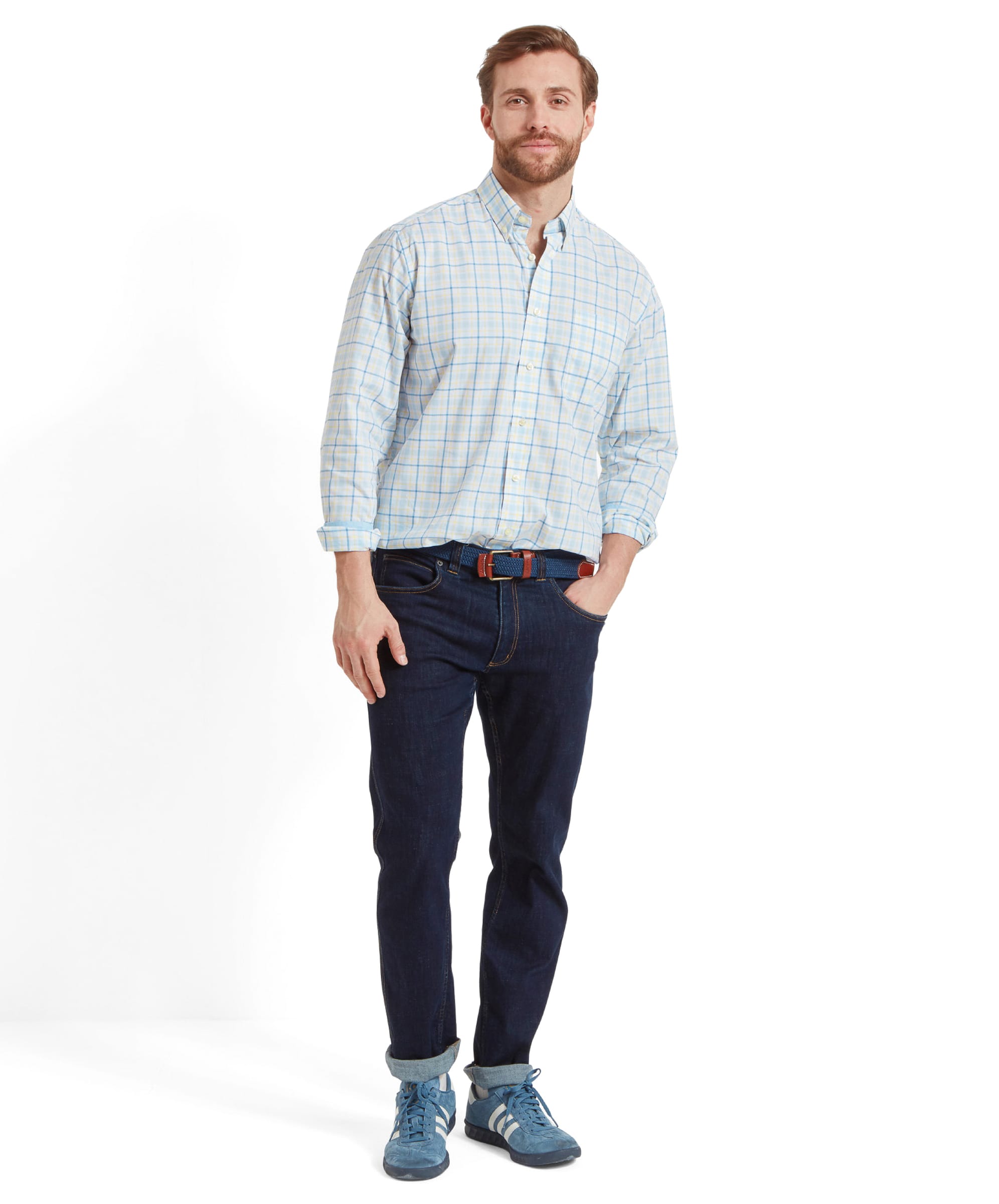 Full-body view of the man wearing the Schöffel Polstead Classic Shirt for Men in Blue and Yellow, paired with dark jeans and blue trainers.