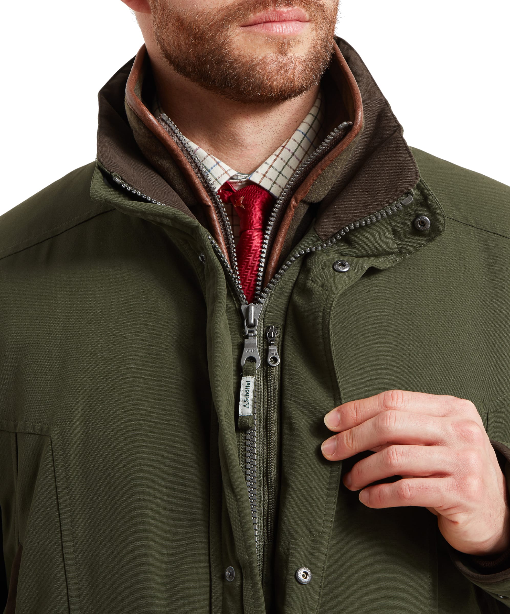 Close-up of the Schöffel Ptarmigan Classic Coat for Men in Green's front zip area, showcasing the double-zip feature and the high collar for added warmth and protection.