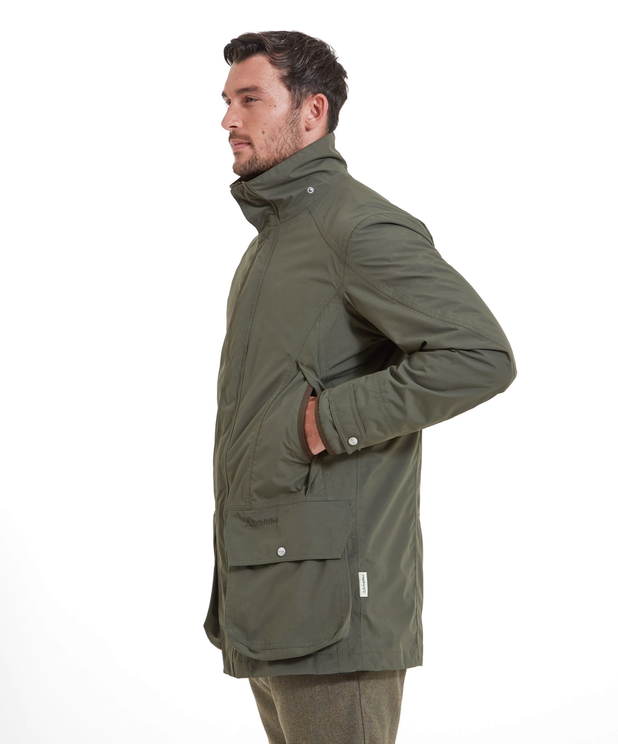 A man stands to his side wearing the Schöffel Ptarmigan Ultralight II for Men in Green, standing with his hand in his pocket.