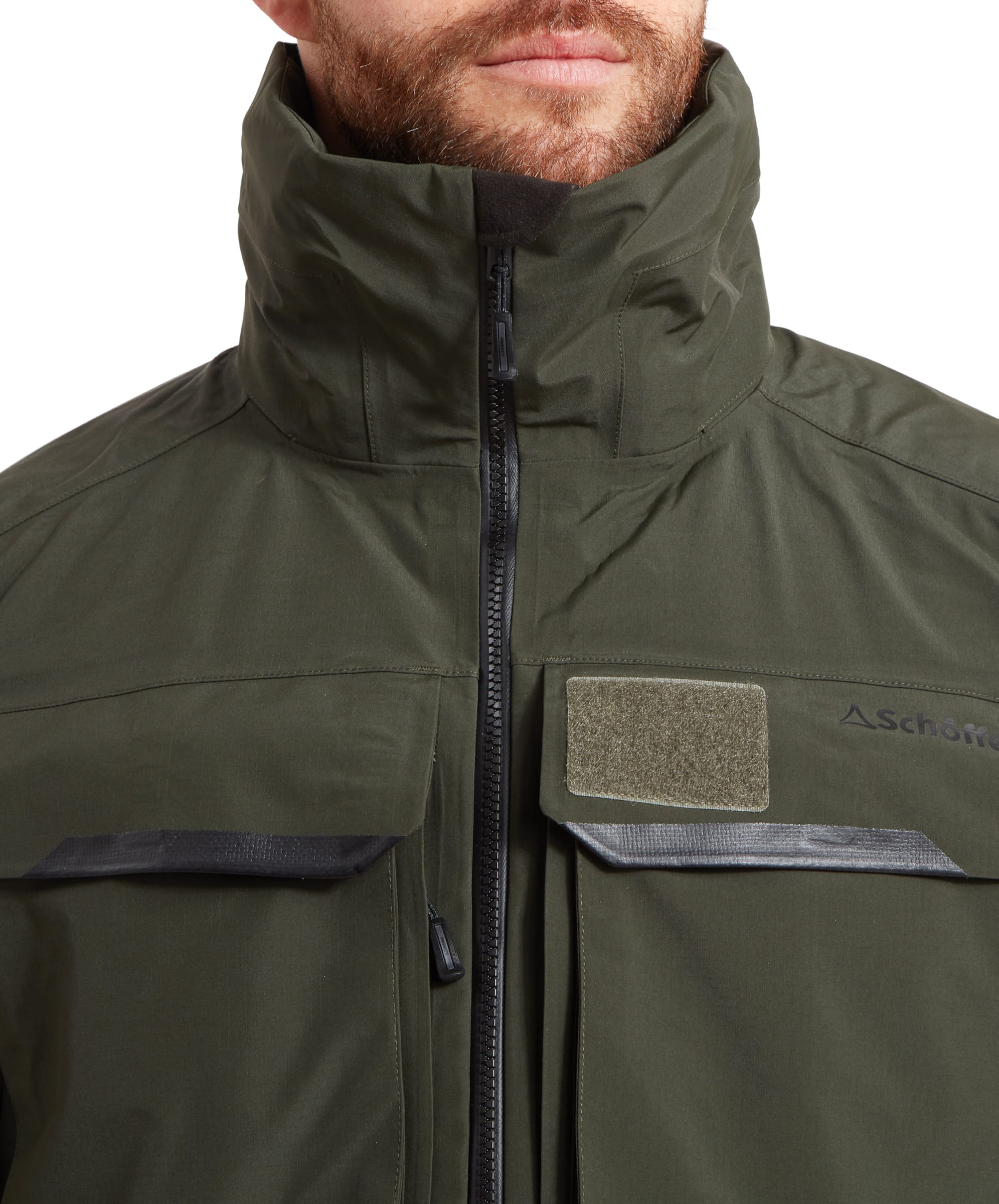 Close-up to the chest area of the Schöffel Salar II Wading Jacket for Men in Green highlighting the plethora of pockets and a velcro patch for fishing licenses. The zip can be seen clearly with a fully waterproof design.