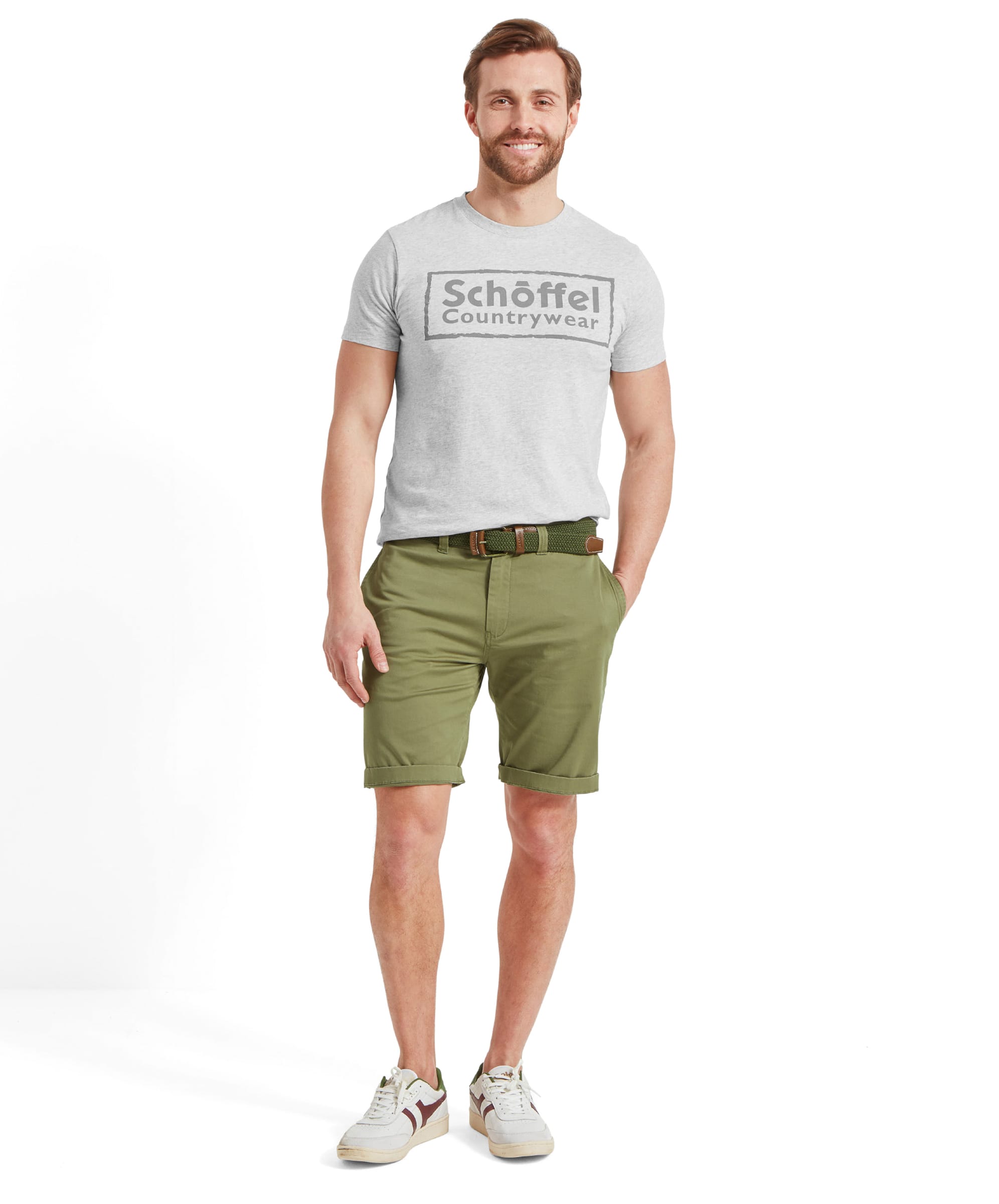 Full body view of a man wearing the Schöffel Heritage T-Shirt for Men in Grey with a pair of green shorts, a green woven belt and white trainers.