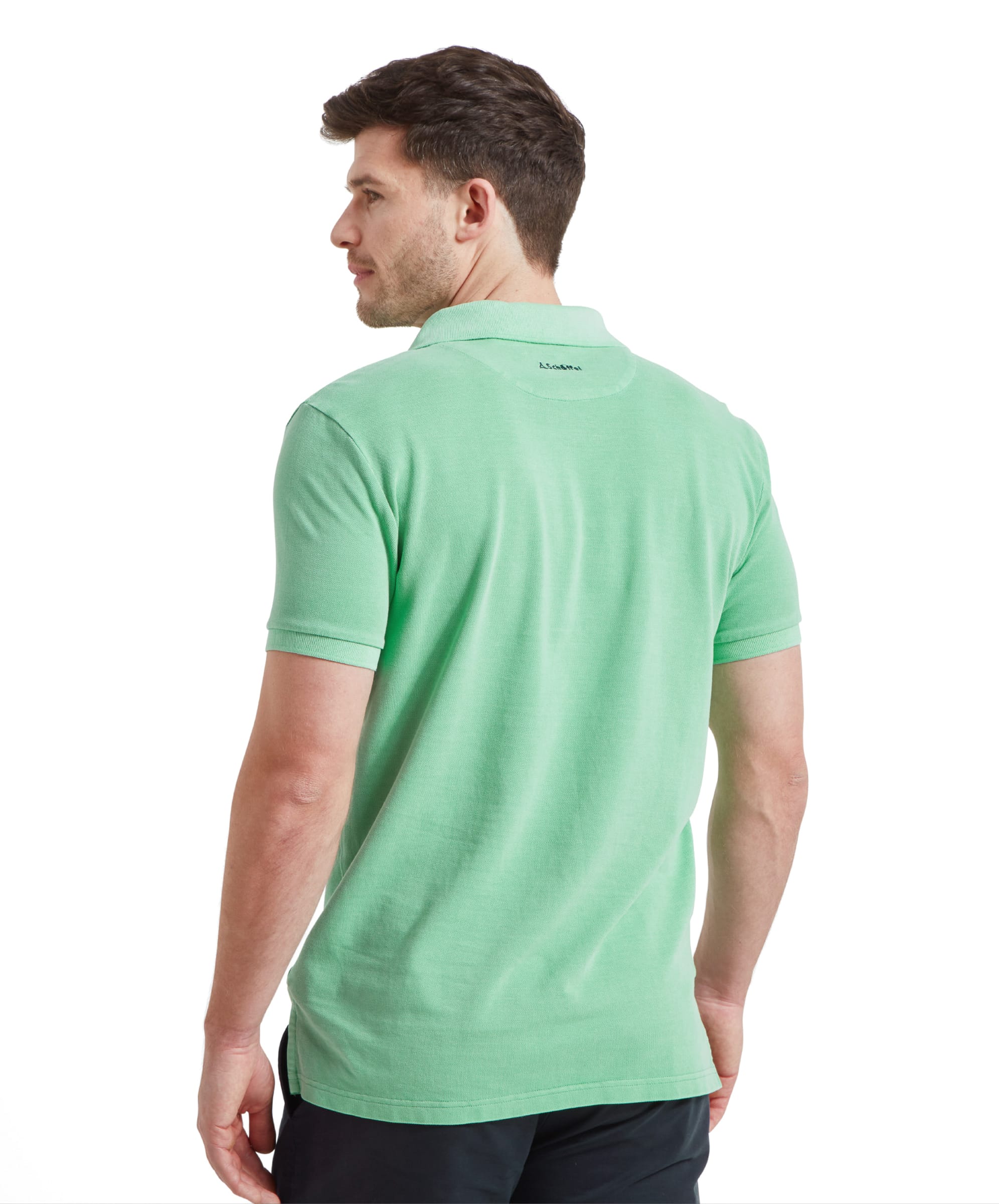 Back view of a man wearing the Schöffel St Ives Garment Dyed Polo Shirt for Men in Green highlighting the fit and the embroidery on the back of the neck in navy thread.