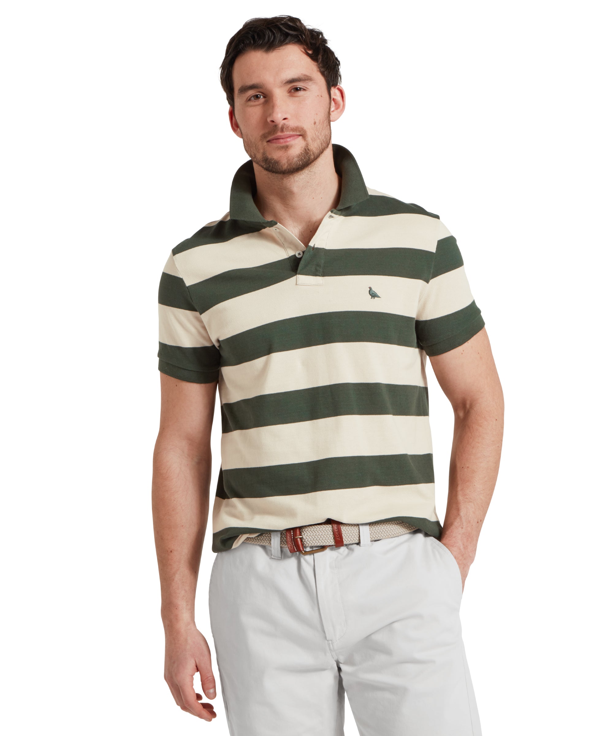 A close up image of a male model wearing a green and beige striped Schöffel polo shirt with a small embroidered bird logo on the chest, paired with light grey shorts. He is standing in a relaxed pose with one hand in his pocket.