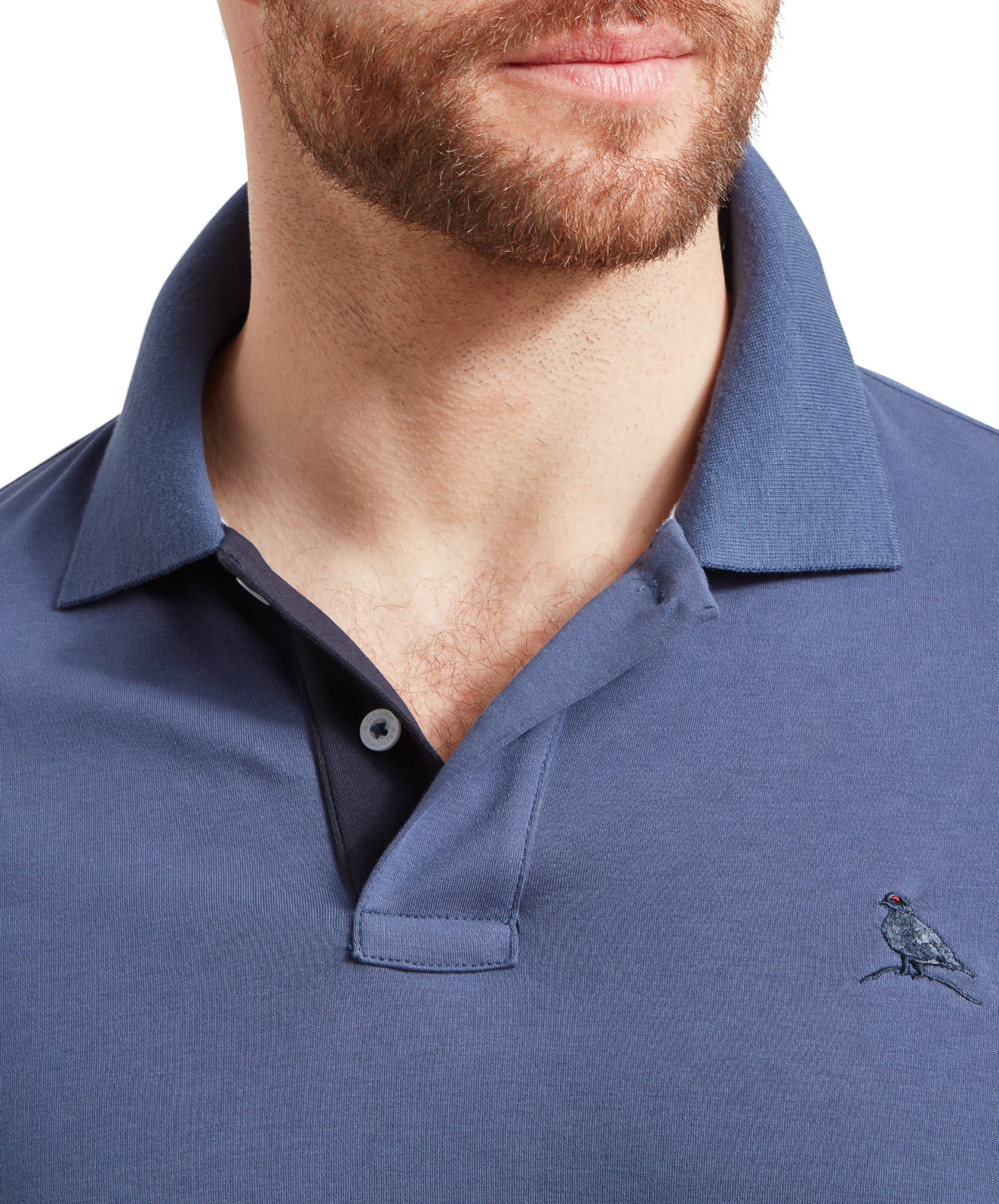 Close-up of the Schöffel St Ives Jersey Polo Shirt for Men in Blue, focusing on the embroidered logo of a bird on the chest and the detailed texture of the fabric.