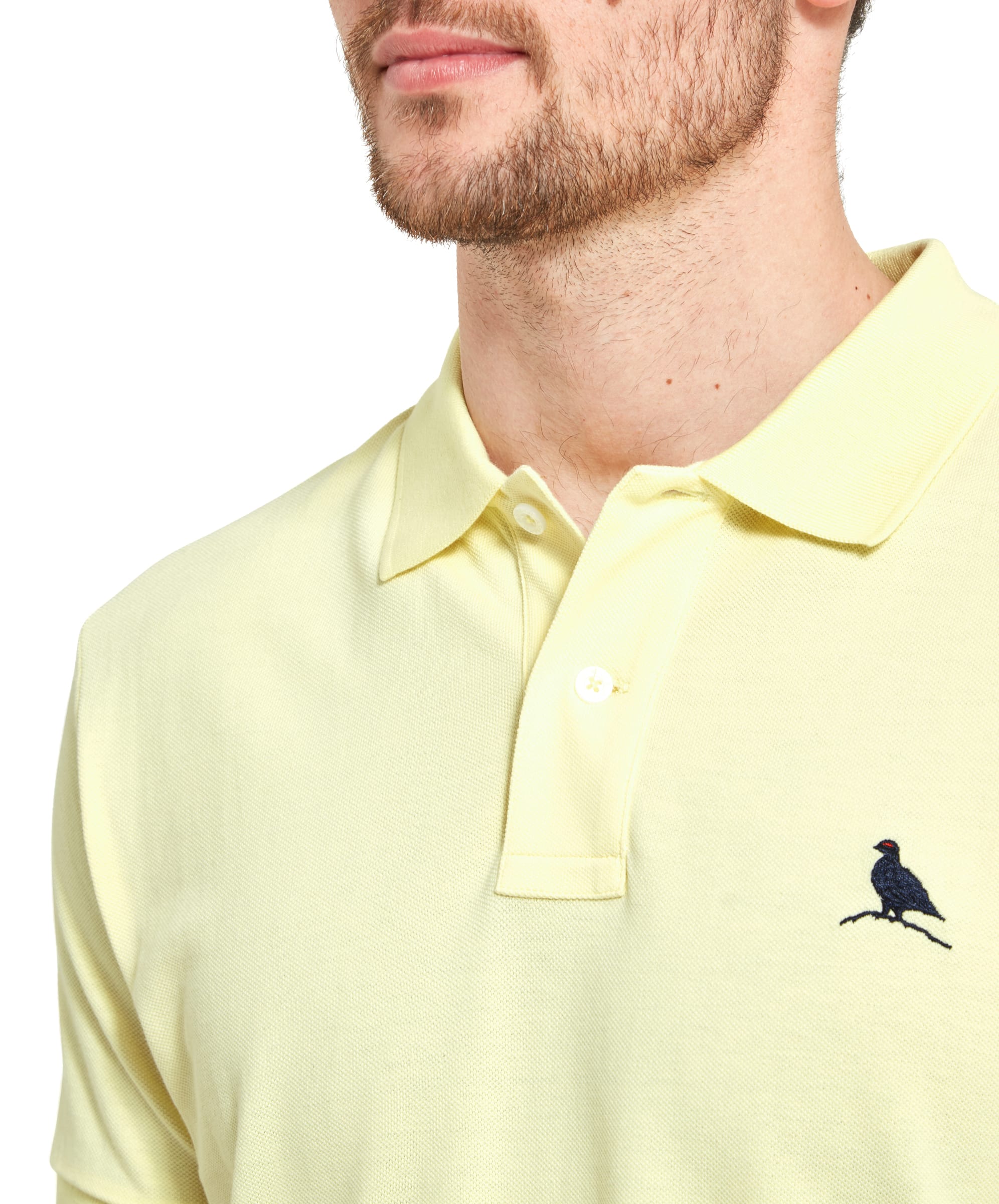 Close-up of the collar area of the Schöffel St Ives Polo Shirt for Men in Light Yellow, showcasing the button details and the embroidered bird logo on the left chest. The collar is neatly folded, and the shirt has a clean, crisp appearance.