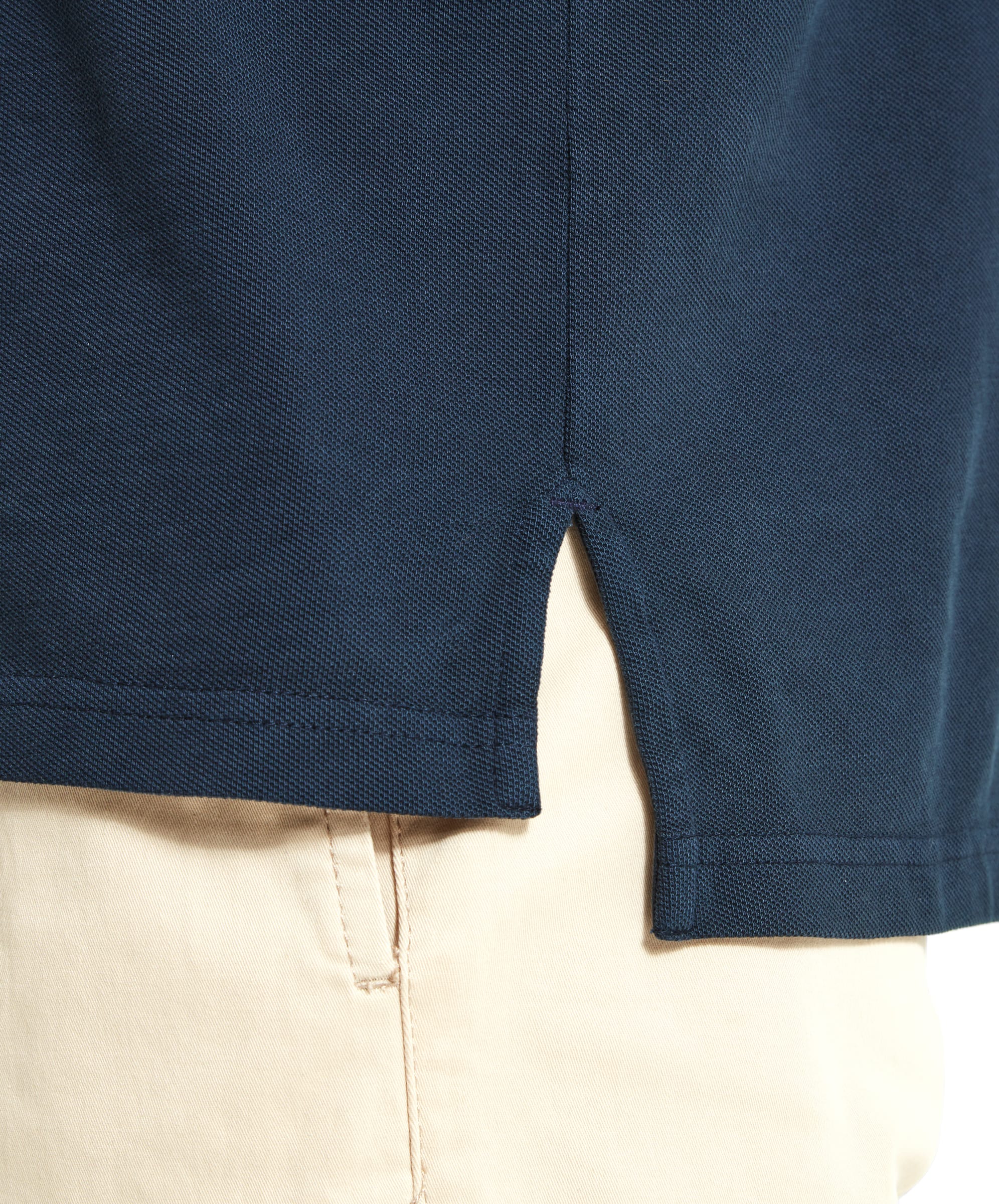 A detailed view of the Schöffel St Ives Polo Shirt for Men in Navy's hem, showing a side slit design and neat stitching, emphasizing the quality of the garment.