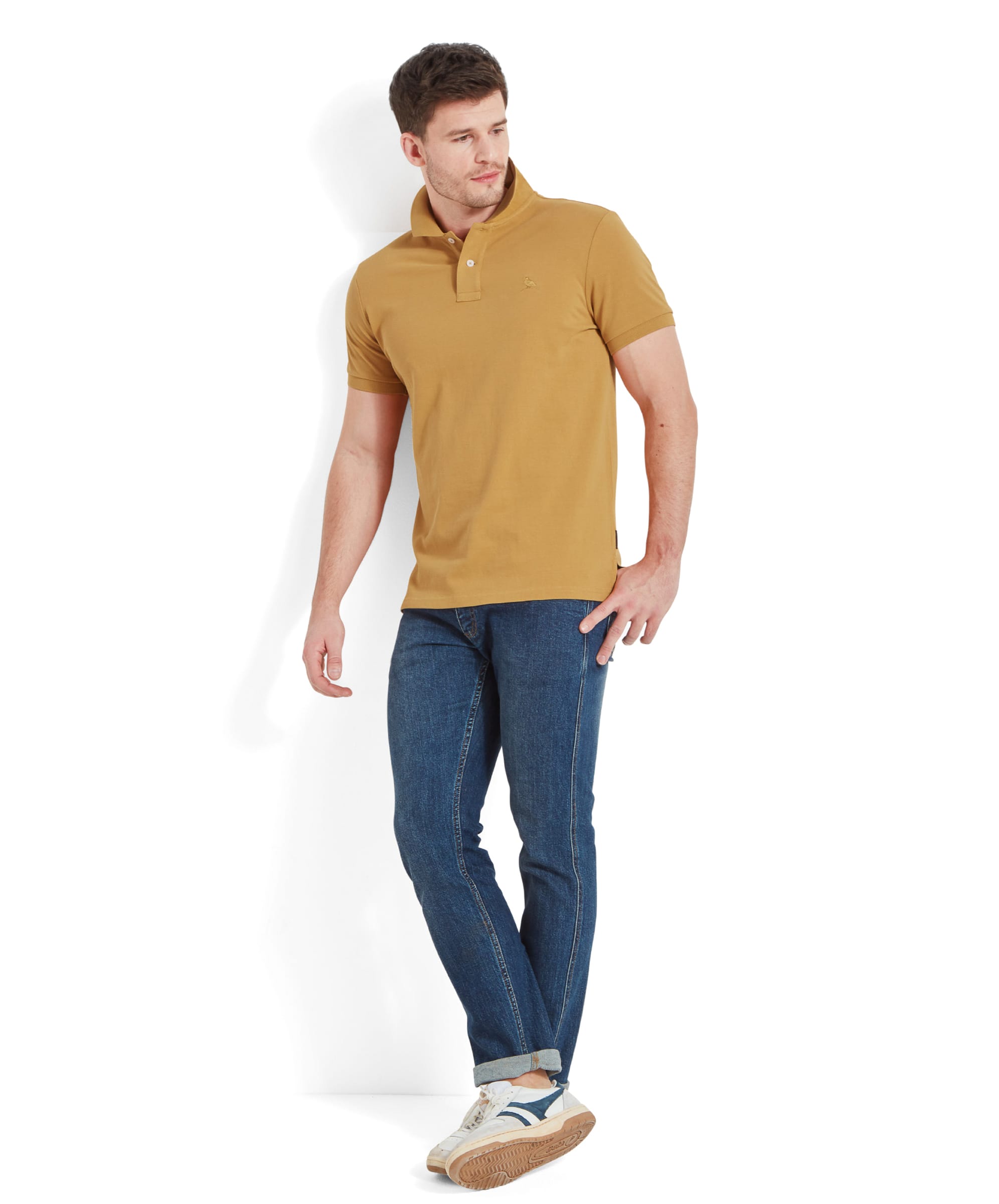 The same man in a full-body shot, wearing the Schöffel St Ives Polo Shirt for Men in Yellow and blue jeans. He stands casually against a white background, looking off to the side.