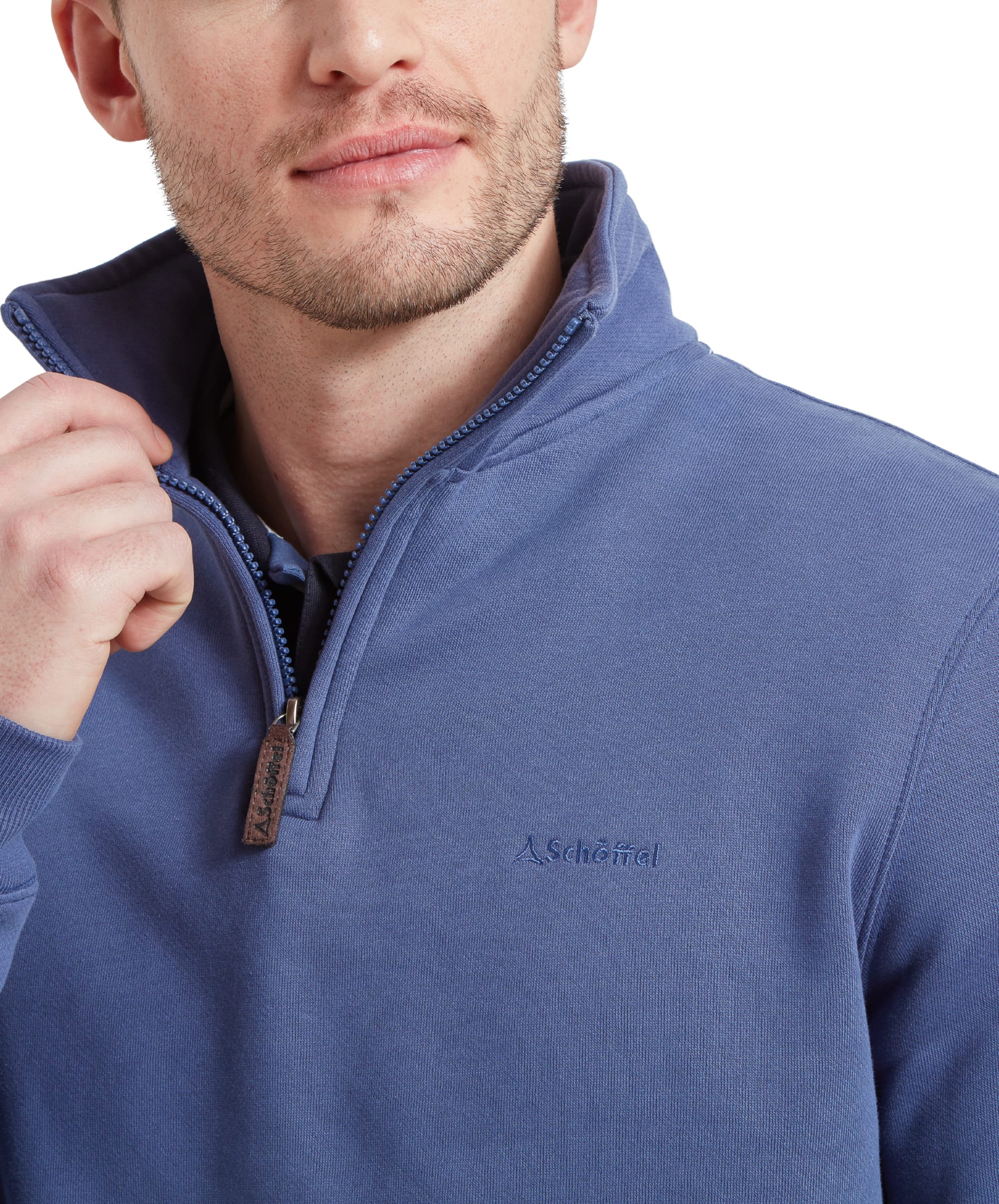 A close-up of the collar area features the zipper detail on the Schöffel St Merryn Sweatshirt for Men in Light Blue and the subtle embroidered logo, showcasing the garment's craftsmanship and attention to detail.