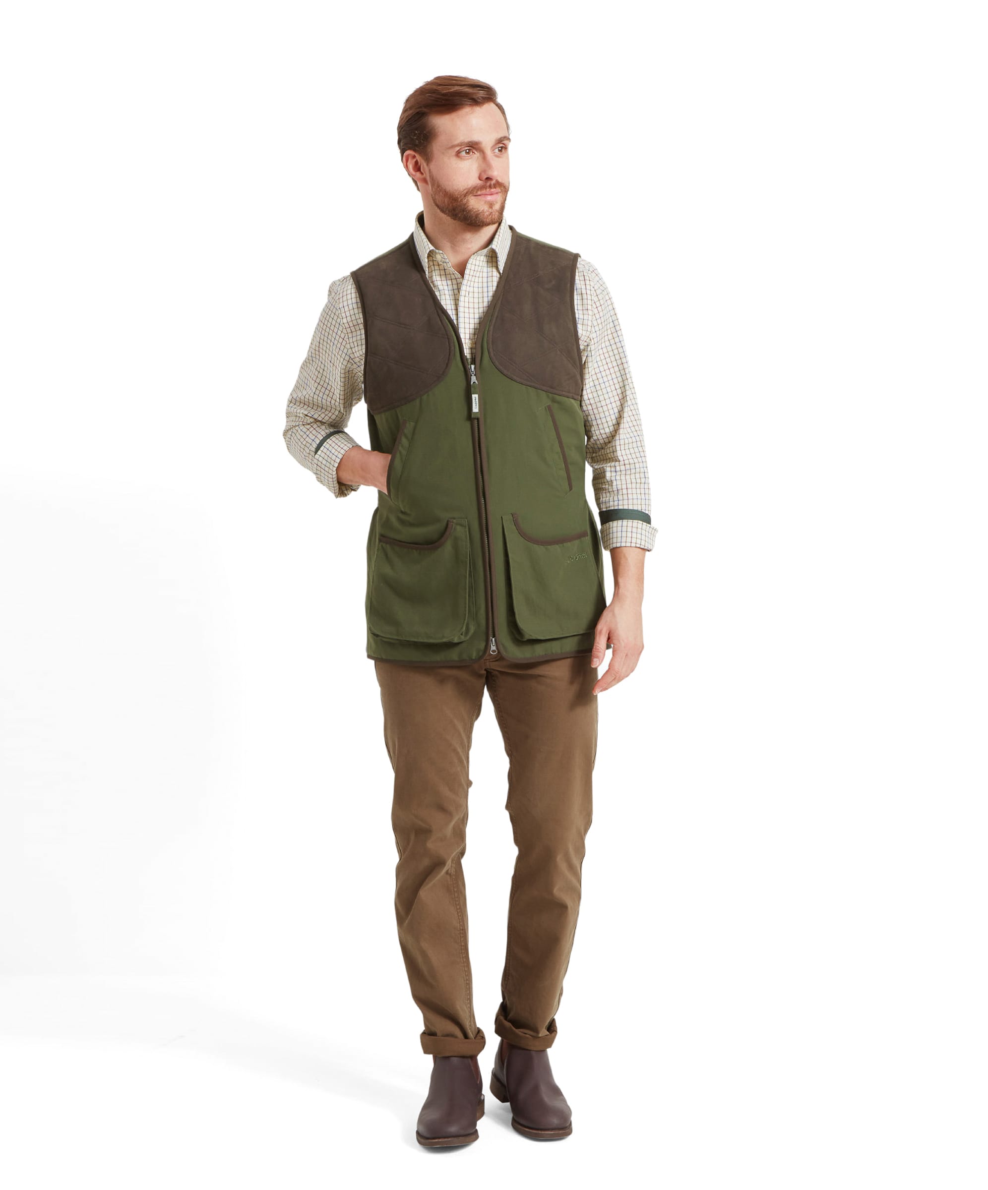 Another full body shot of a man walking casually with his hand in the handwarmer pocket of the Schöffel Stamford Vest II for Men in Green