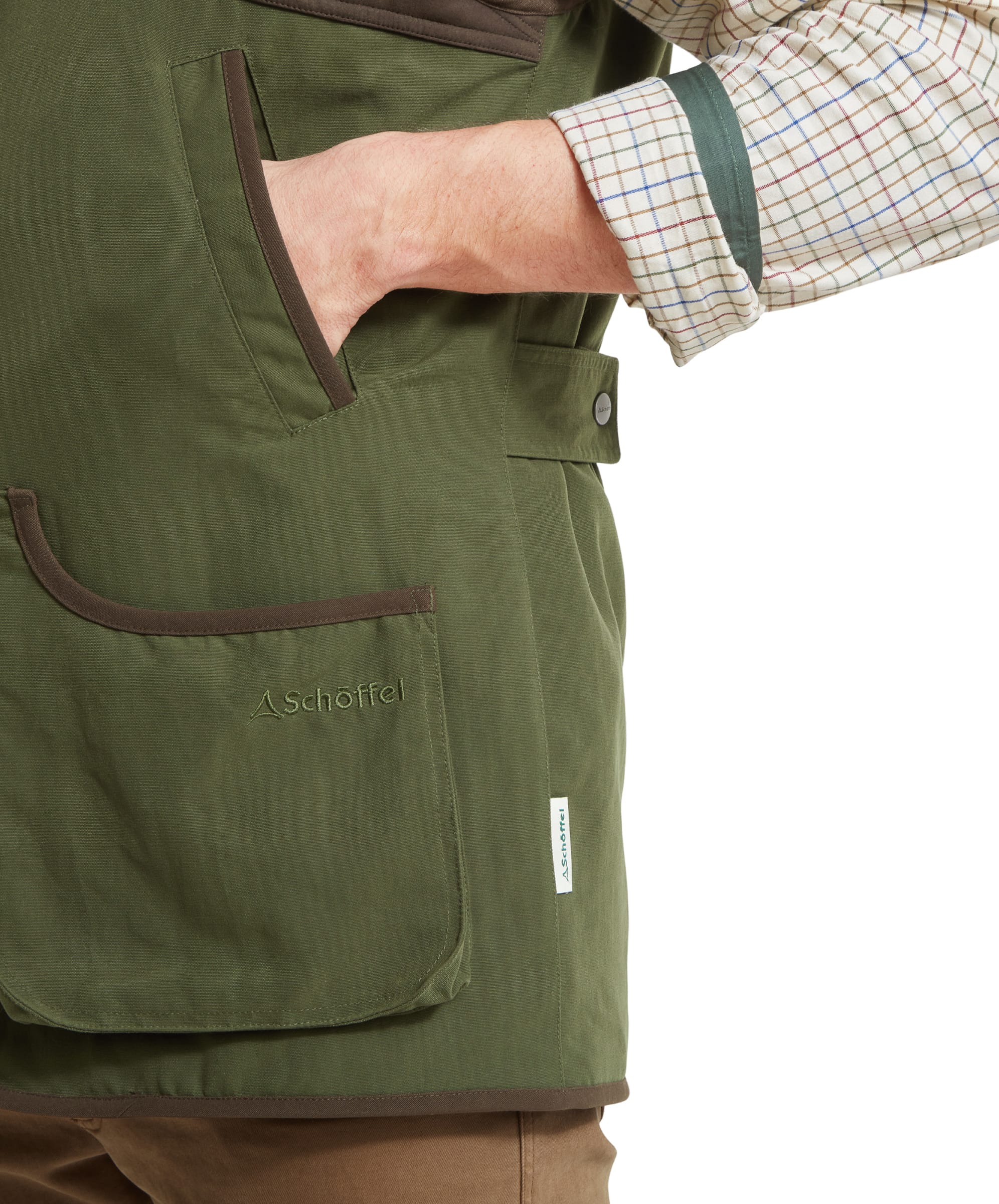 Close-up of the various pockets found on the Schöffel Stamford Vest II for Men in Green; one being the handwarmer slot pocket and the larger billow pocket, both finished with a suedette style fabric trim.