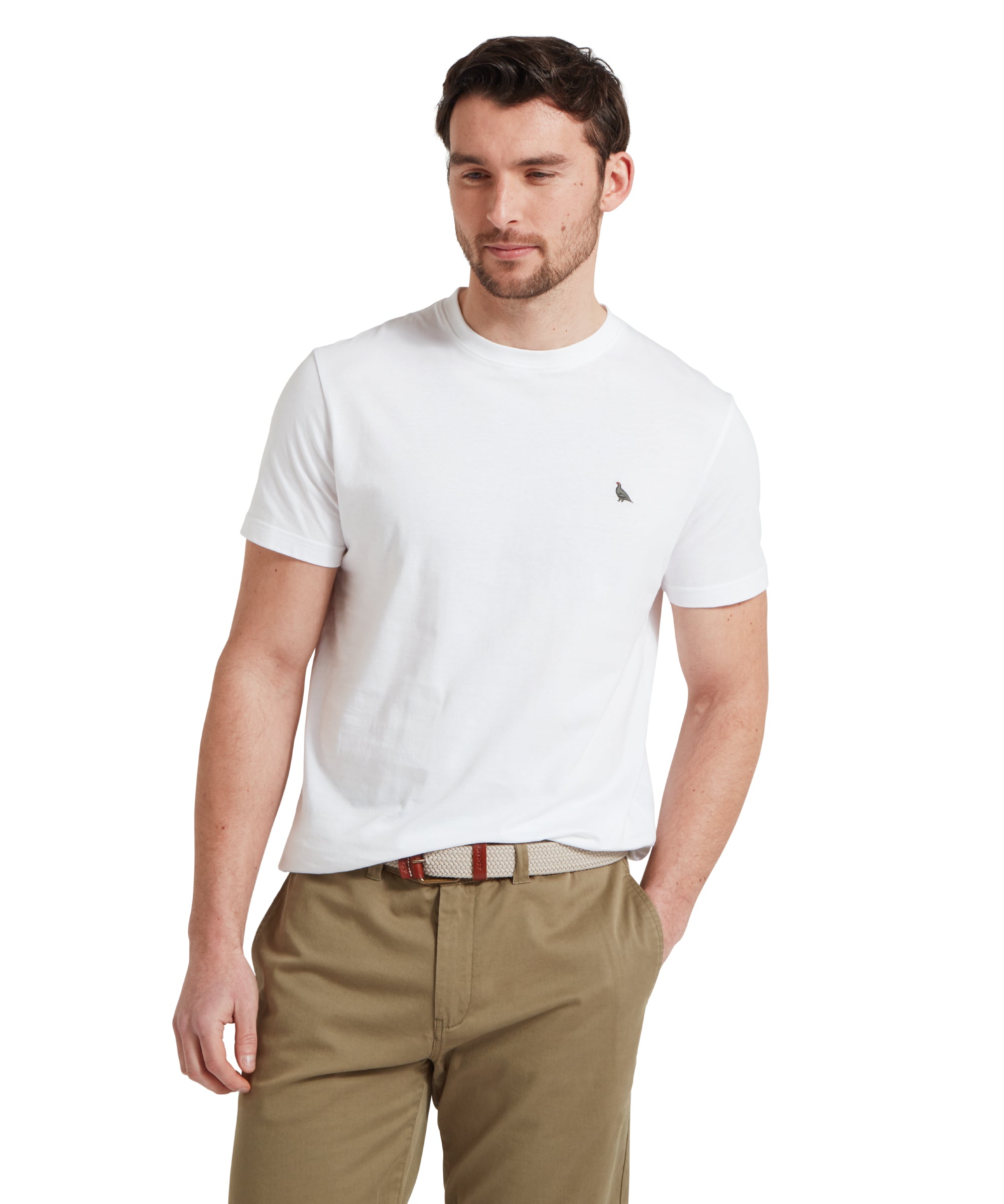 Close-up of a male model wearing a white Schöffel t-shirt with a small embroidered bird logo on the chest, paired with khaki shorts and a woven belt.