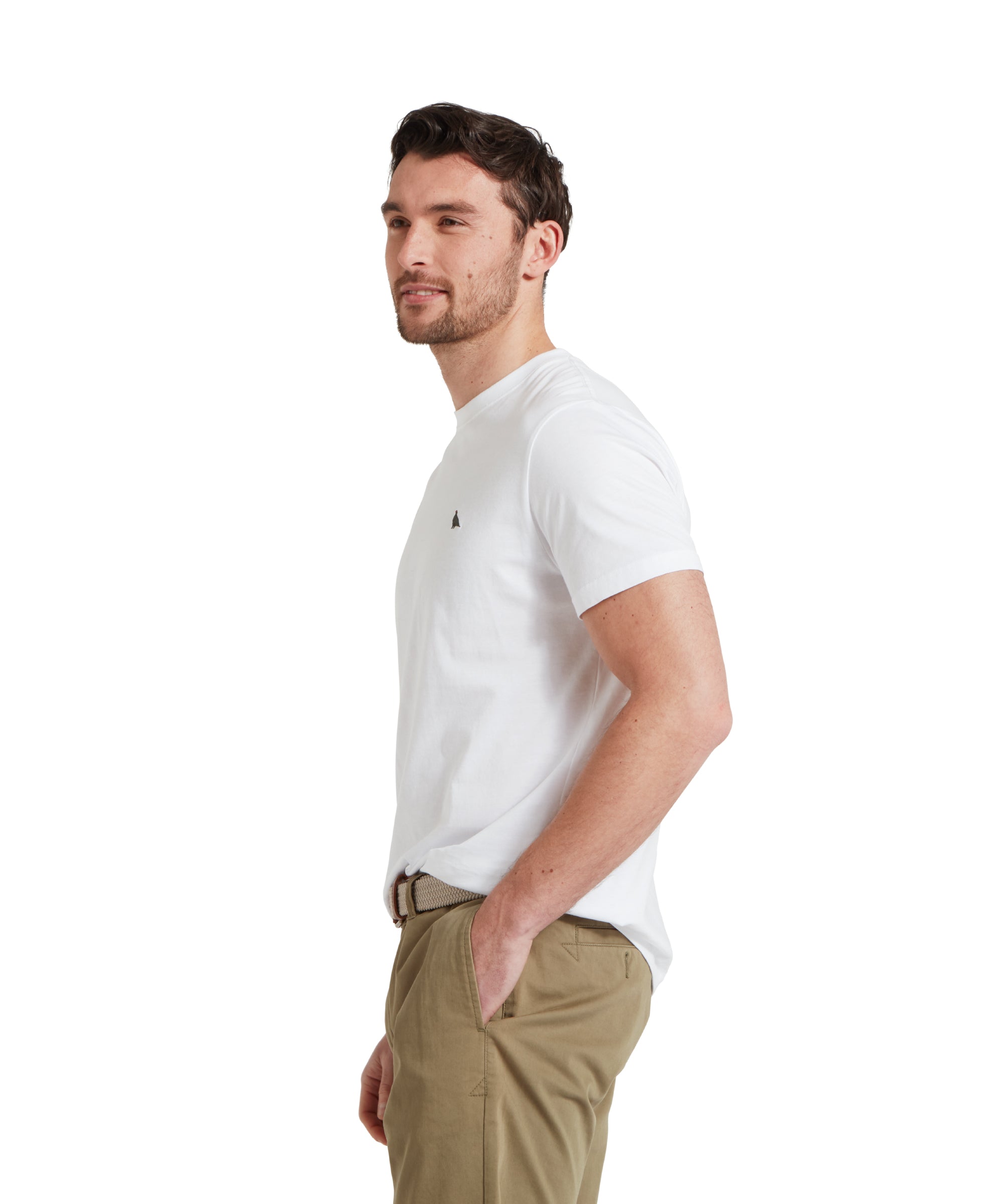 Male model in a white T-shirt and khaki shorts standing sideways with hands in pockets, facing left, against a white background.