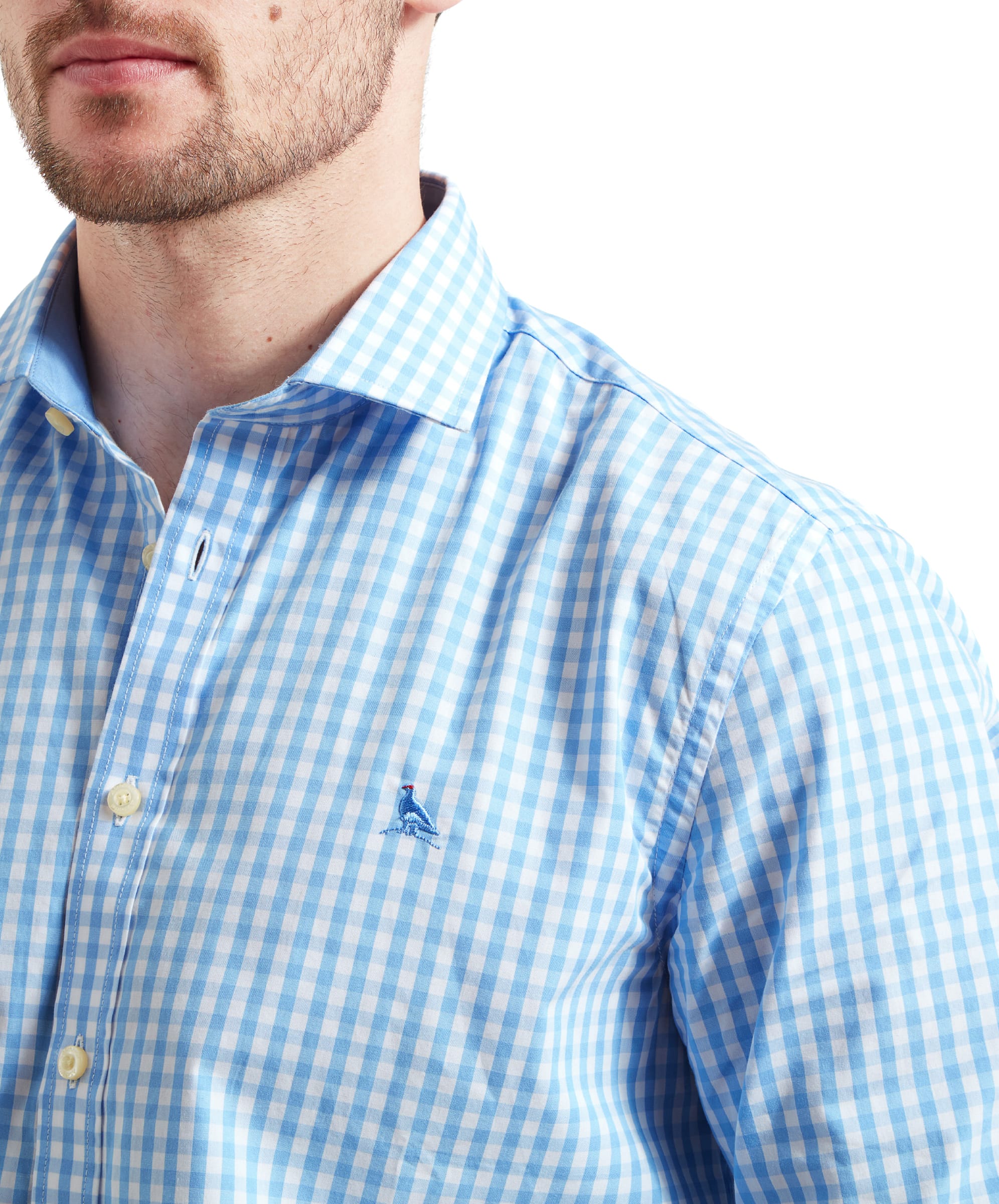 A close-up of the chest area on the Schöffel Thorpeness Tailored Shirt for Men in Blue, focusing on the blue gingham pattern and the embroidered logo on the shirt's left side.