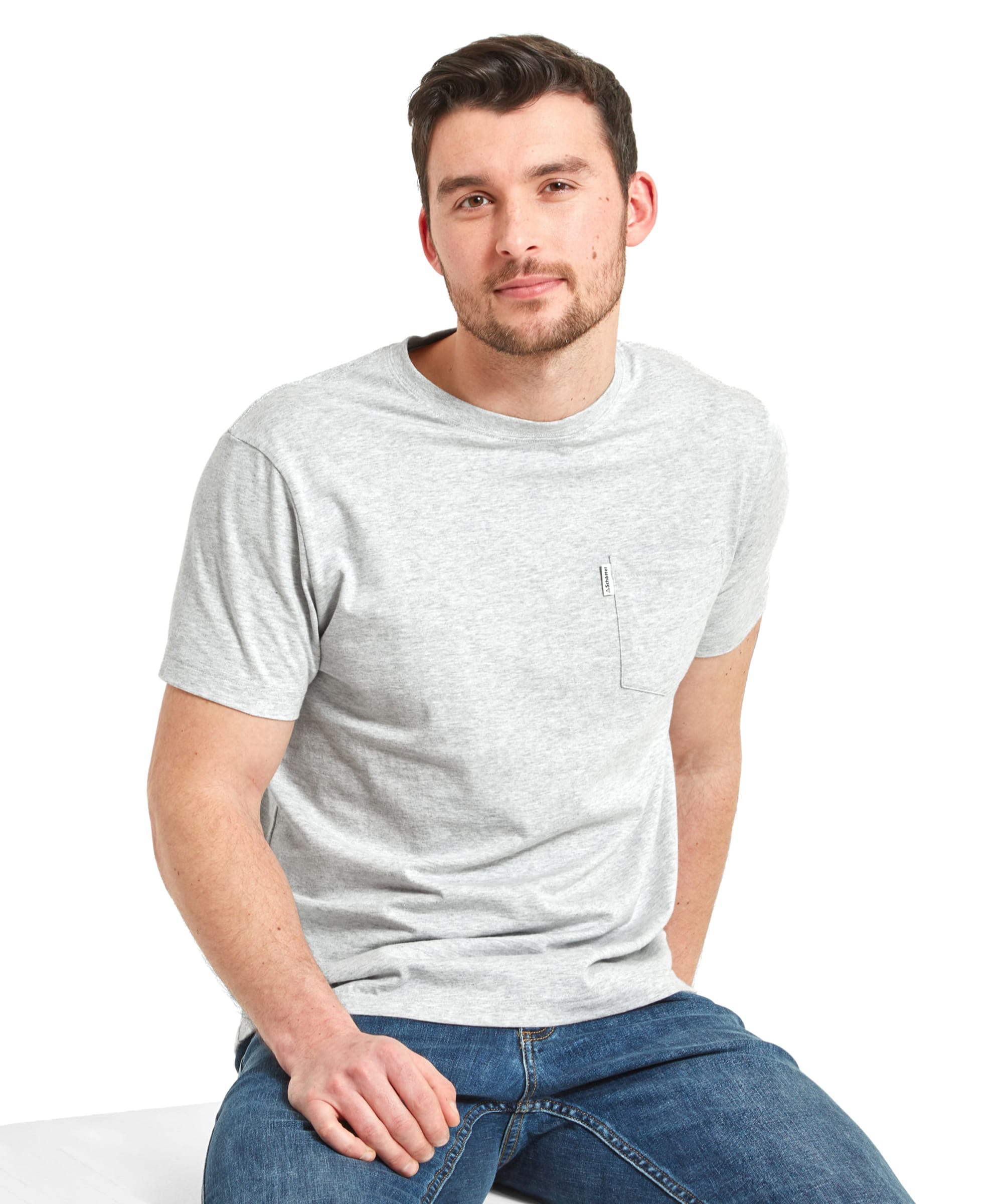 A man is seated, wearing a Schöffel Towan T-Shirt for Men in Grey and jeans. He is looking at the camera with a slight smile.