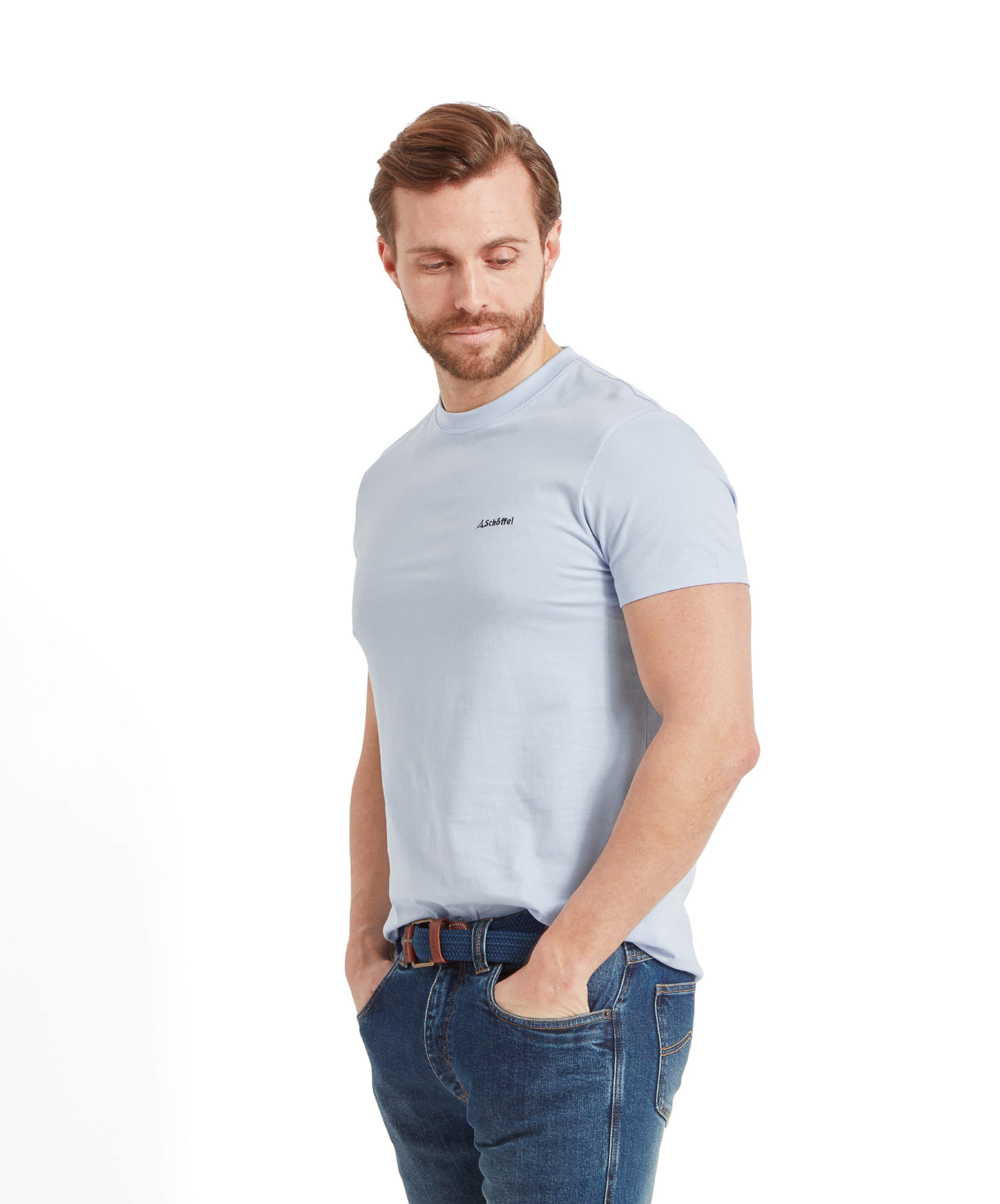 The side view of the man in a Schöffel Trevone T-Shirt for Men in Blue and jeans, with a slight smile, looking off to the side.