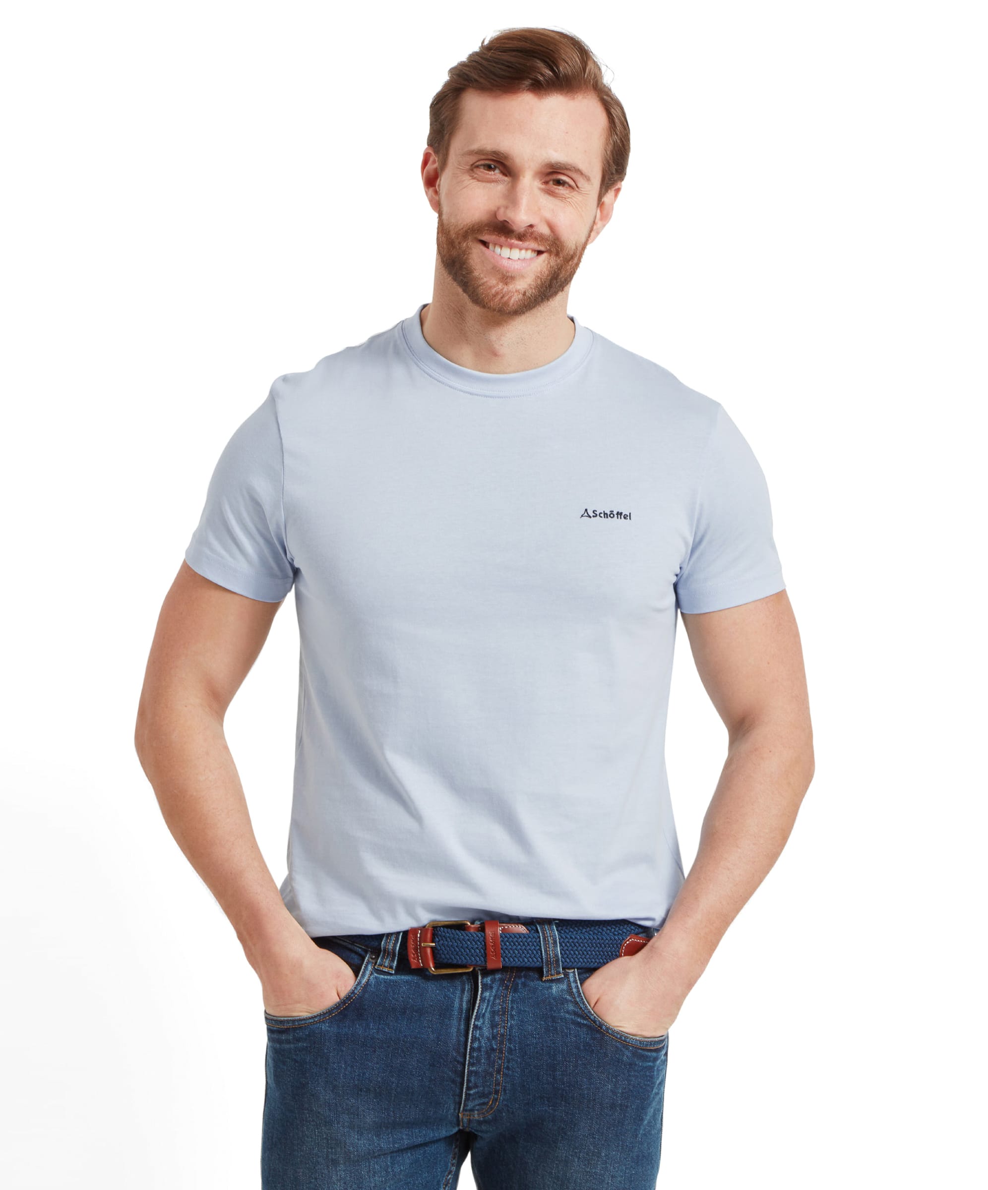 A smiling man in a Schöffel Trevone T-Shirt for Men in Blue and jeans, standing with both hands in his pockets.