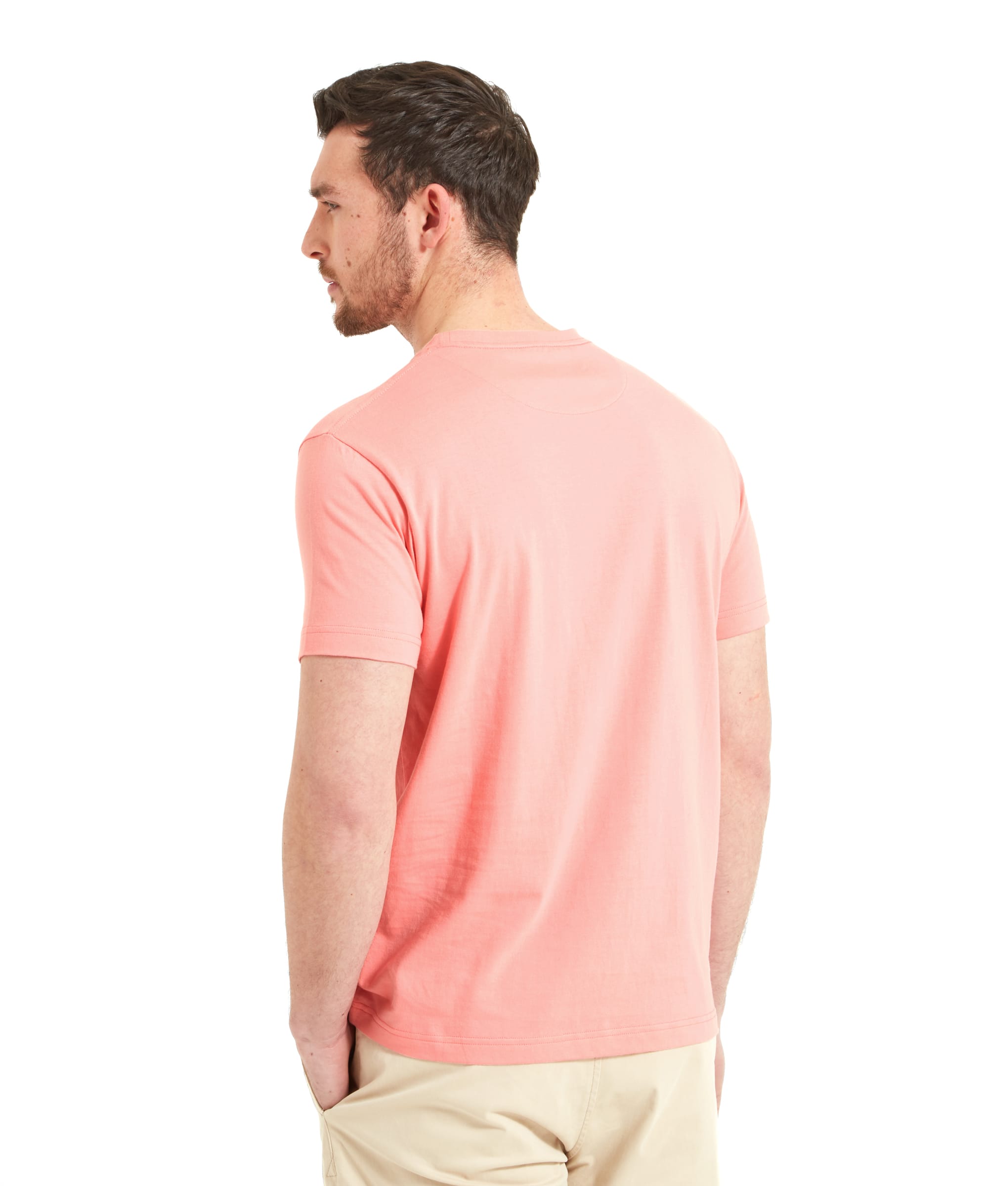 Back view of the man in the Schöffel Trevone T-Shirt for Men in Pink and beige shorts, looking to the left, showing the simple design of the back of the T-shirt.