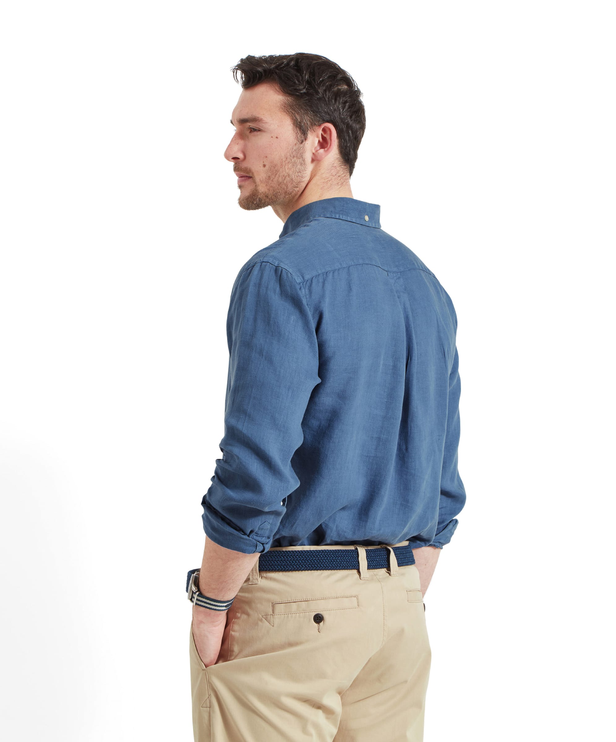 A back view of the man in the Schöffel Walsingham Linen Shirt for Men in Blue, showing the shirt's yoke and pleats, highlighting the shirt's craftsmanship and comfortable fit.