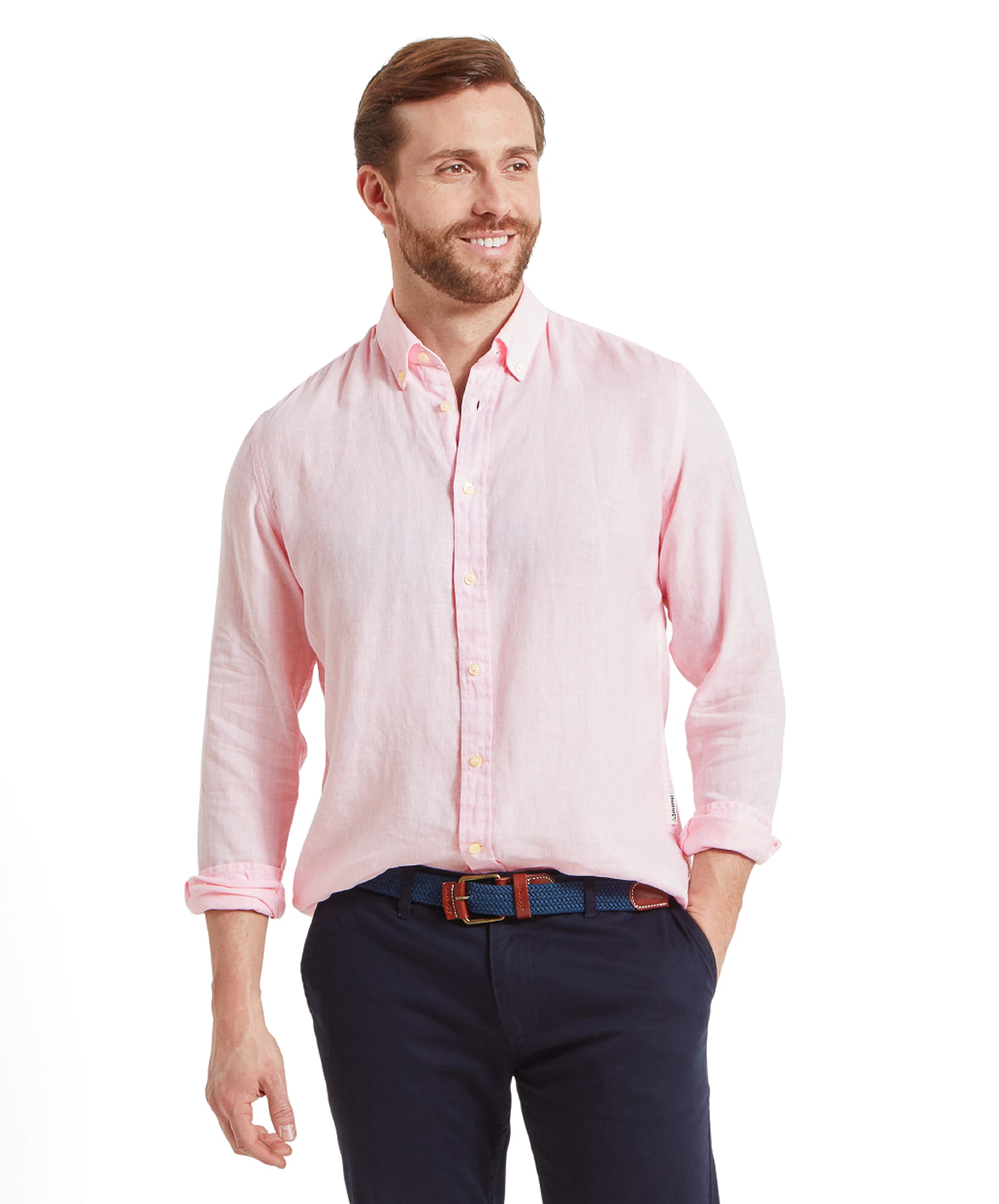 A man wearing a Schöffel Walsingham Linen Shirt for Men in Pink. The shirt features long sleeves, a button-down collar, and a relaxed fit. The man has a slight smile and is posing with his hands in his pockets, showcasing the shirt's casual and comfortable style.