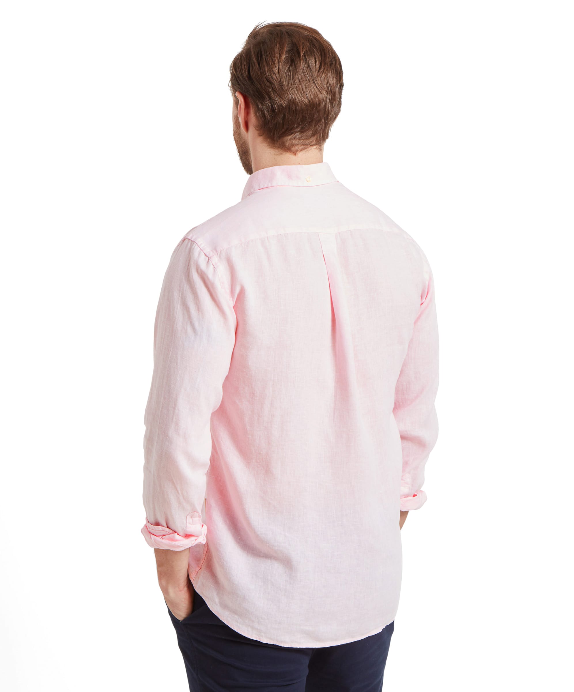 The man is seen from the back, displaying the back detail of the Schöffel Walsingham Linen Shirt for Men in Pink. The shirt has a classic cut with a slight yoke and a pleat for comfort. The linen fabric appears lightweight and breathable, ideal for warm weather.