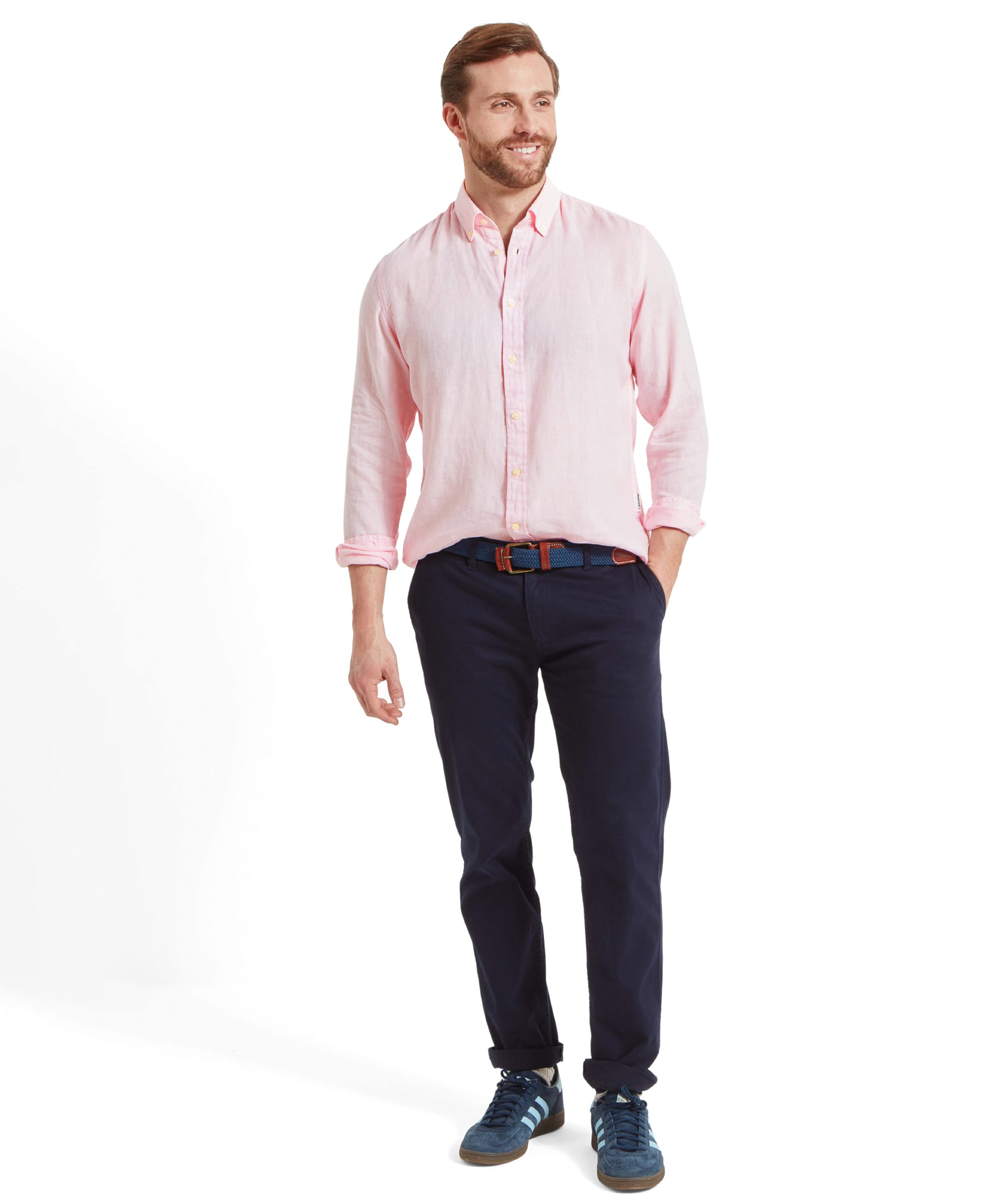 Another full-body shot similar to the second image, showing the man in the Schöffel Walsingham Linen Shirt for Men in Pink and navy trousers, with a casual stance and a relaxed expression.