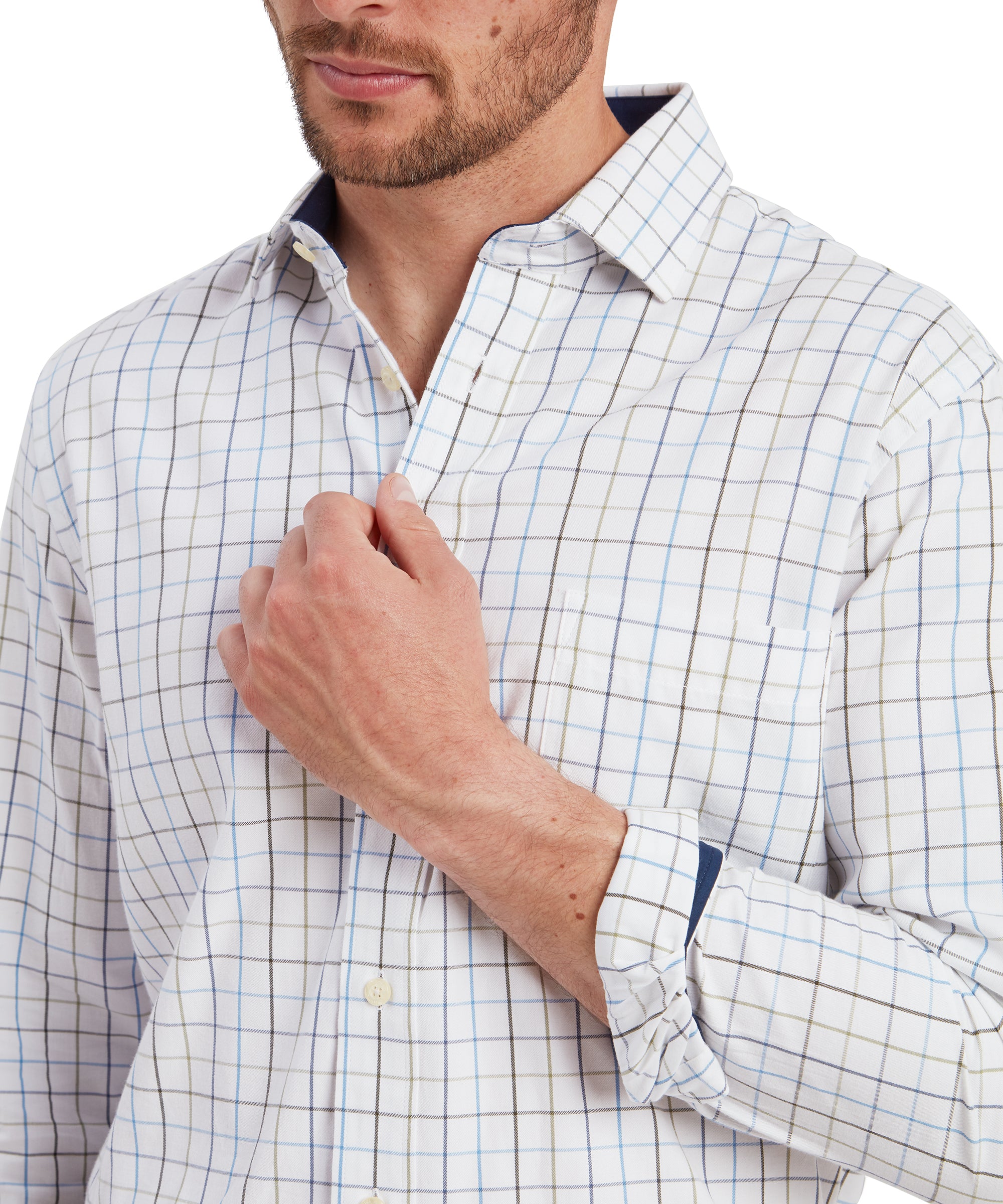 A close-up shot focuses on the upper part of the shirt, emphasising the details of the checkered pattern, button-down collar, and chest pocket. The man's hand is lightly gripping the front of the Schöffel Wells Tailored Shirt for Men in Blue, drawing attention to the fabric's texture and the button placement.