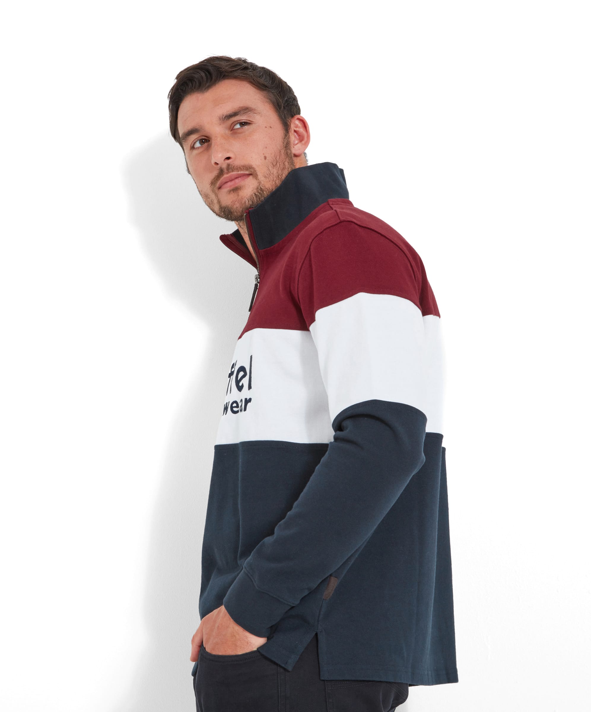 The first image shows a man wearing a Schöffel Exeter Heritage 1/4 Zip for Unisex in Red, featuring maroon on the shoulders, white in the middle, and navy blue at the bottom, with "Schöffel Countrywear" written across the chest. He is standing with a side glance.