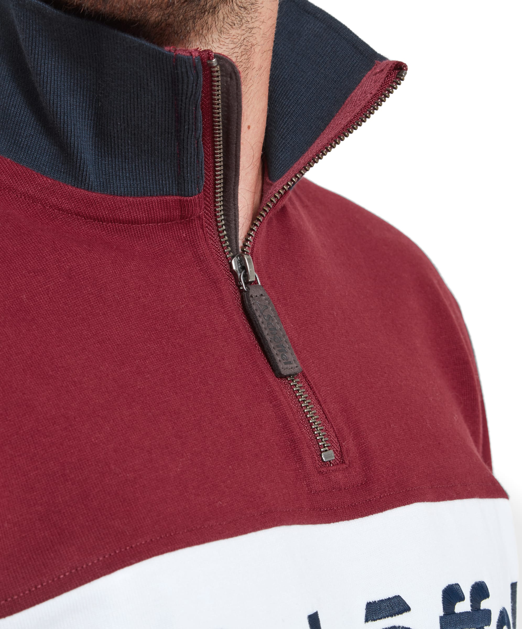 The third image is a close-up of the 1/4 zip detail on the maroon part of the Schöffel Exeter Heritage 1/4 Zip for Unisex in Red, highlighting the zipper and the high collar.