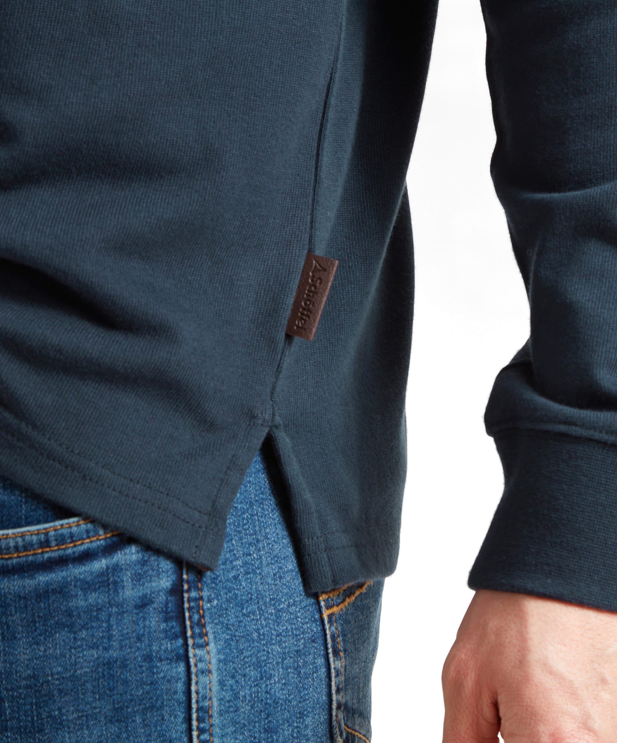 Close-up of the side of the Schöffel Exeter Heritage 1/4 Zip for Unisex in Navy, showing a brown fabric tag with the brand name.