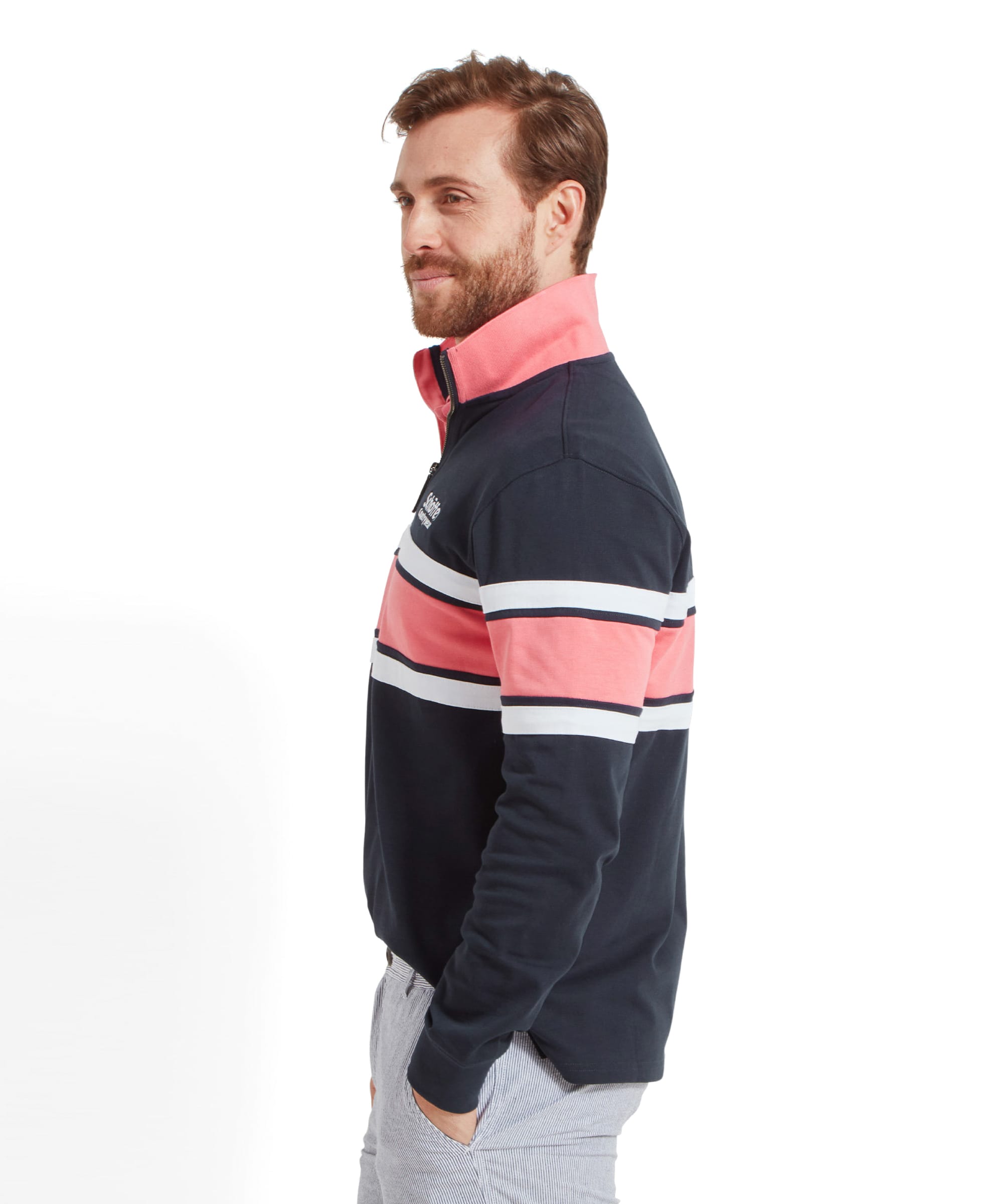 Side profile of the man wearing the Schöffel Exmouth Heritage 1/4 Zip for Unisex in Navy, with his hands in his pockets. He is smiling slightly and looking to the side.