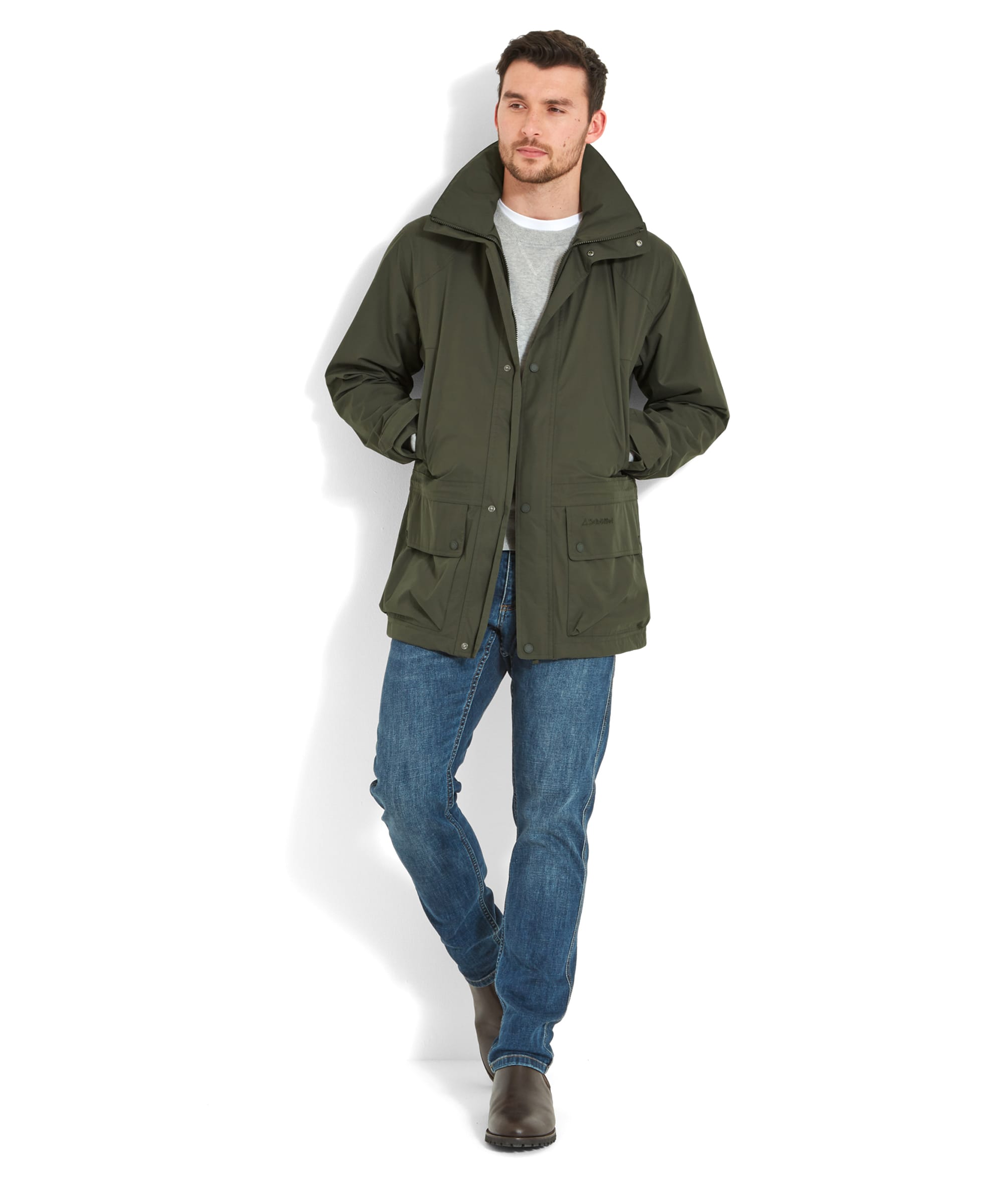 The same man in the Schöffel Unisex Ketton Jacket II in Green, standing straight with his hands in his pockets and one foot slightly forward.