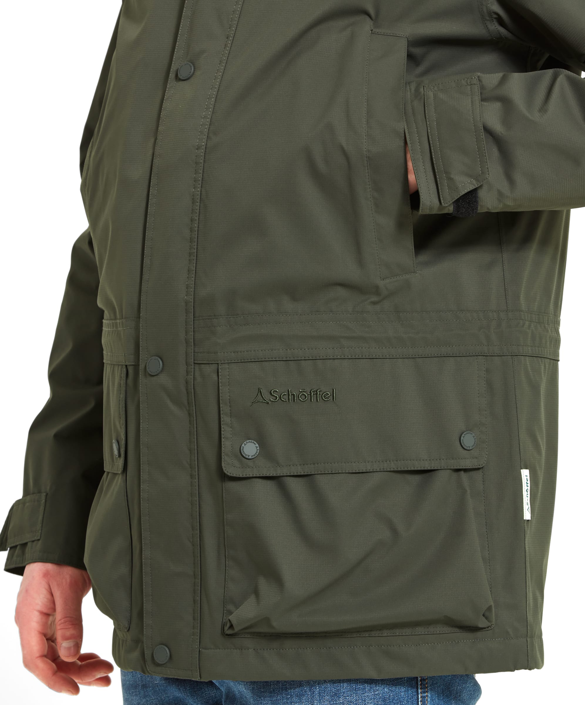 Close-up of the lower part of the Schöffel Unisex Ketton Jacket II in Green, showing the front pockets and embroidered Schoffel logo.