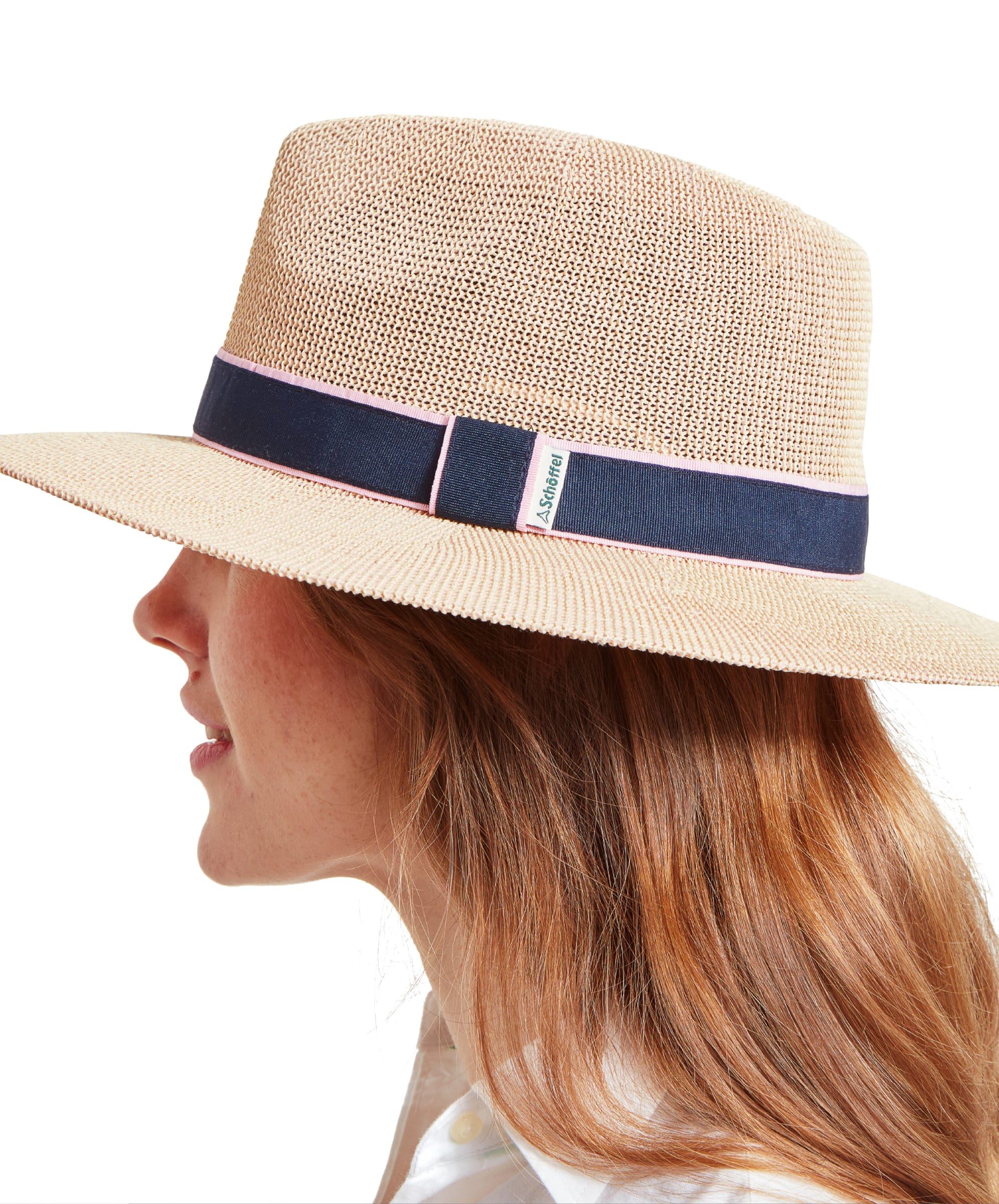 Side view of a woman with auburn hair wearing a Schöffel Unisex Porth Hat in Blue and Pink, looking forward.