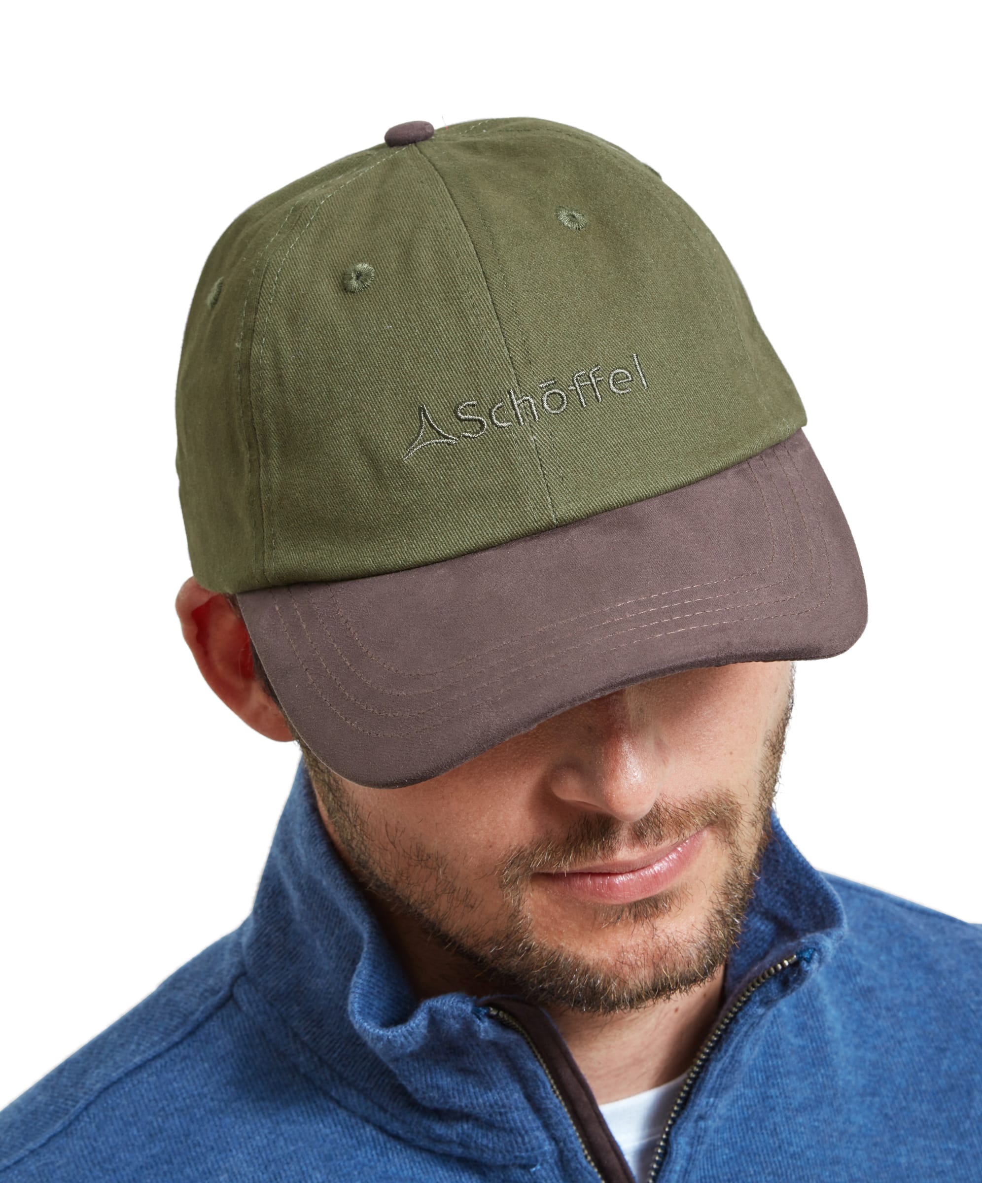 A man wearing a Schöffel Unisex Thurlestone Cap in Green. The cap features the Schöffel logo embroidered on the front. The man is looking down, showcasing the top of the cap.