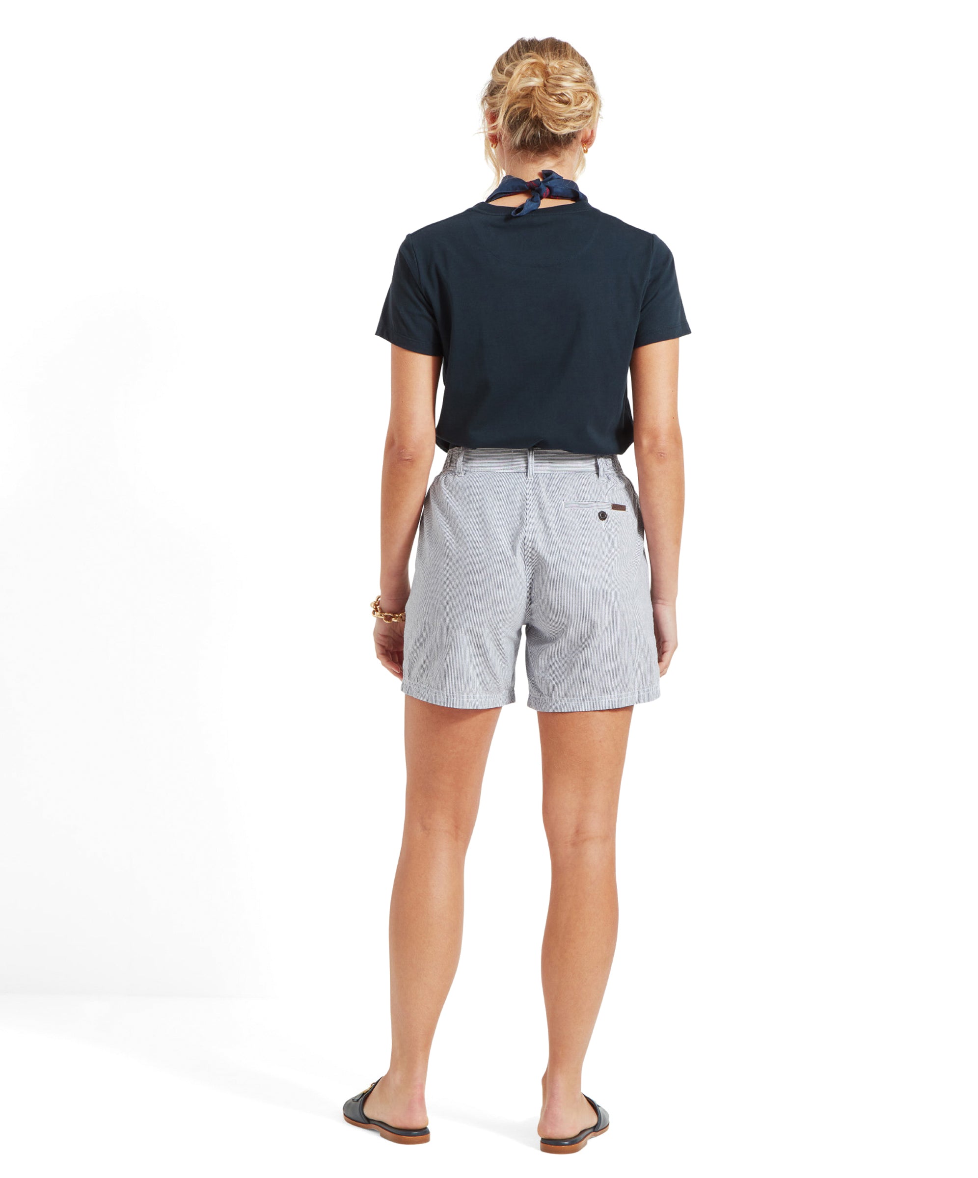 Back view of a model wearing a navy t-shirt, Schöffel Aster Shorts for Women in Navy, and black sandals with hair in a bun.