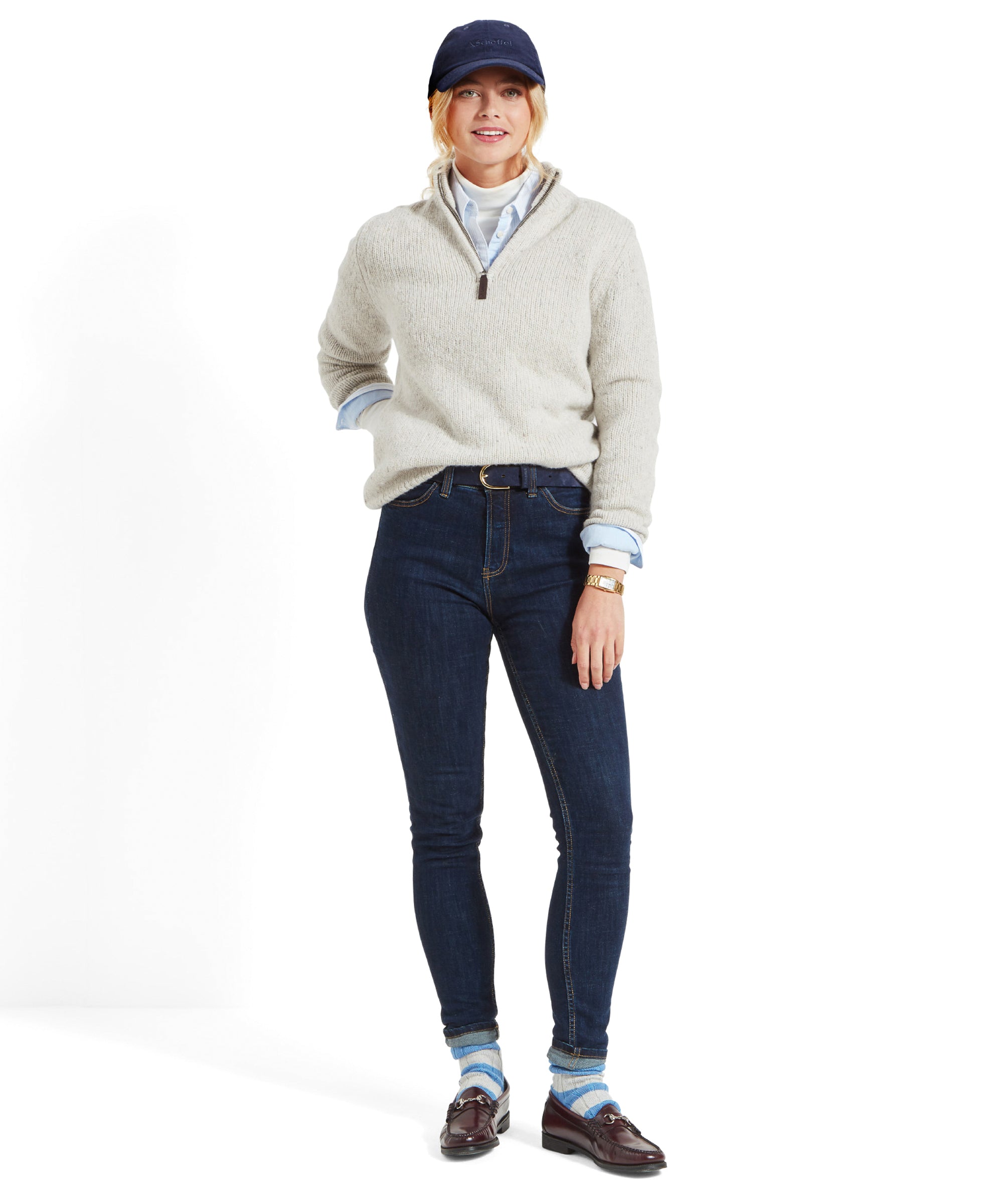 Full body shot of a woman in a Schöffel Women's Aviemore Alpaca Mix 1/4 Zip Jumper for Women in Cream, navy cap, and dark jeans, standing confidently.