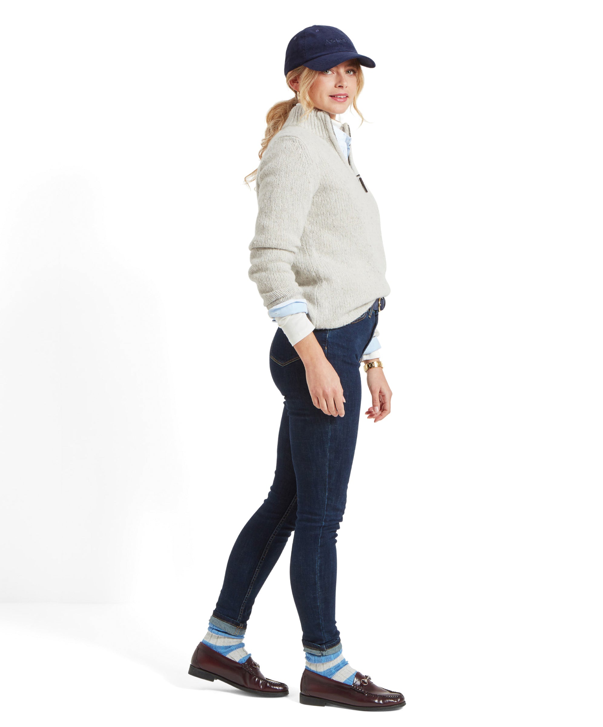 Side view of a woman in a Schöffel Women's Aviemore Alpaca Mix 1/4 Zip Jumper for Women in Cream, her hand in her jeans pocket.