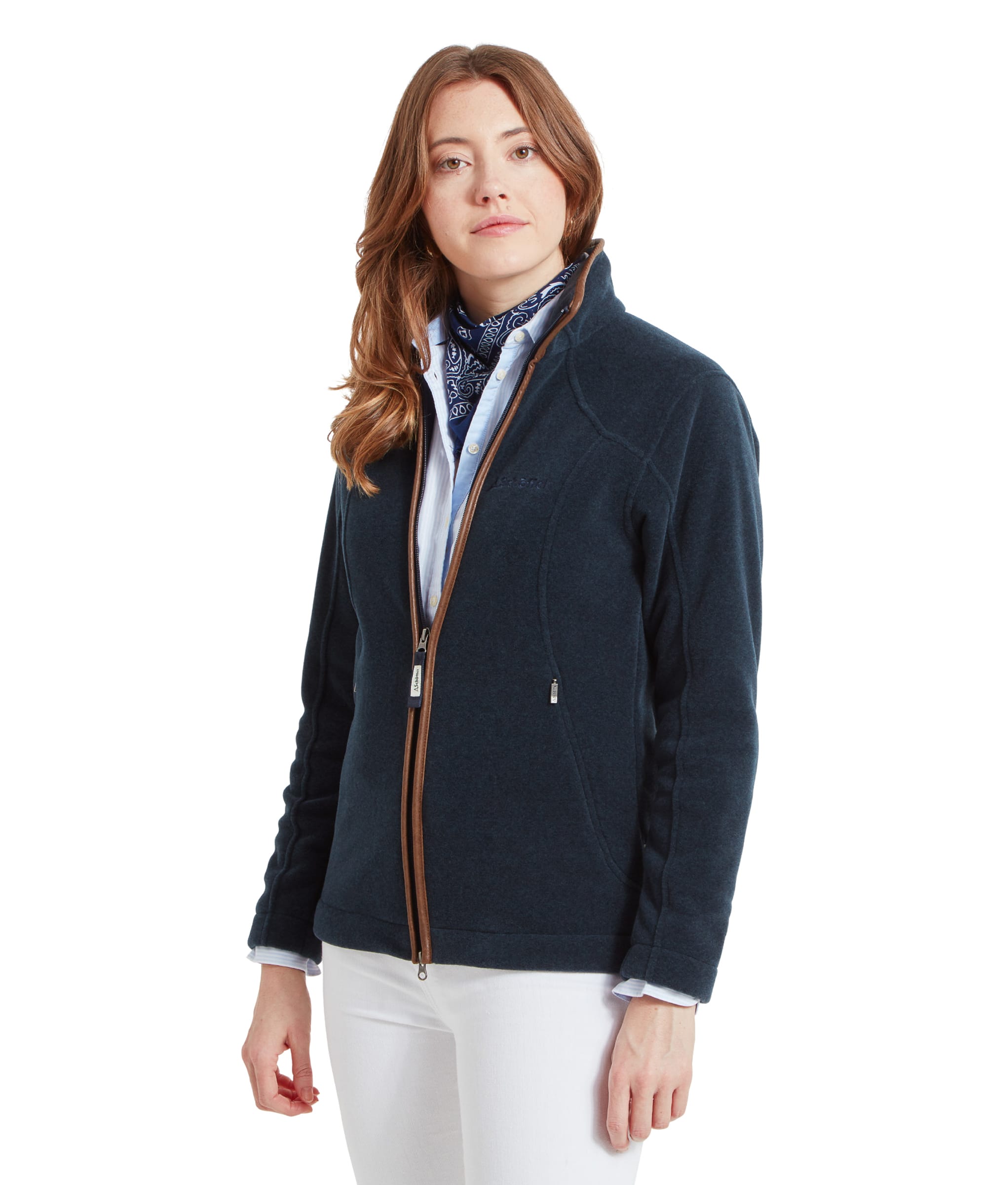 Side view of the woman standing, showing the fitted design of the Schöffel Burley Fleece Jacket for Women in Blue, paired with white jeans and a blue shirt, looking away from the camera.