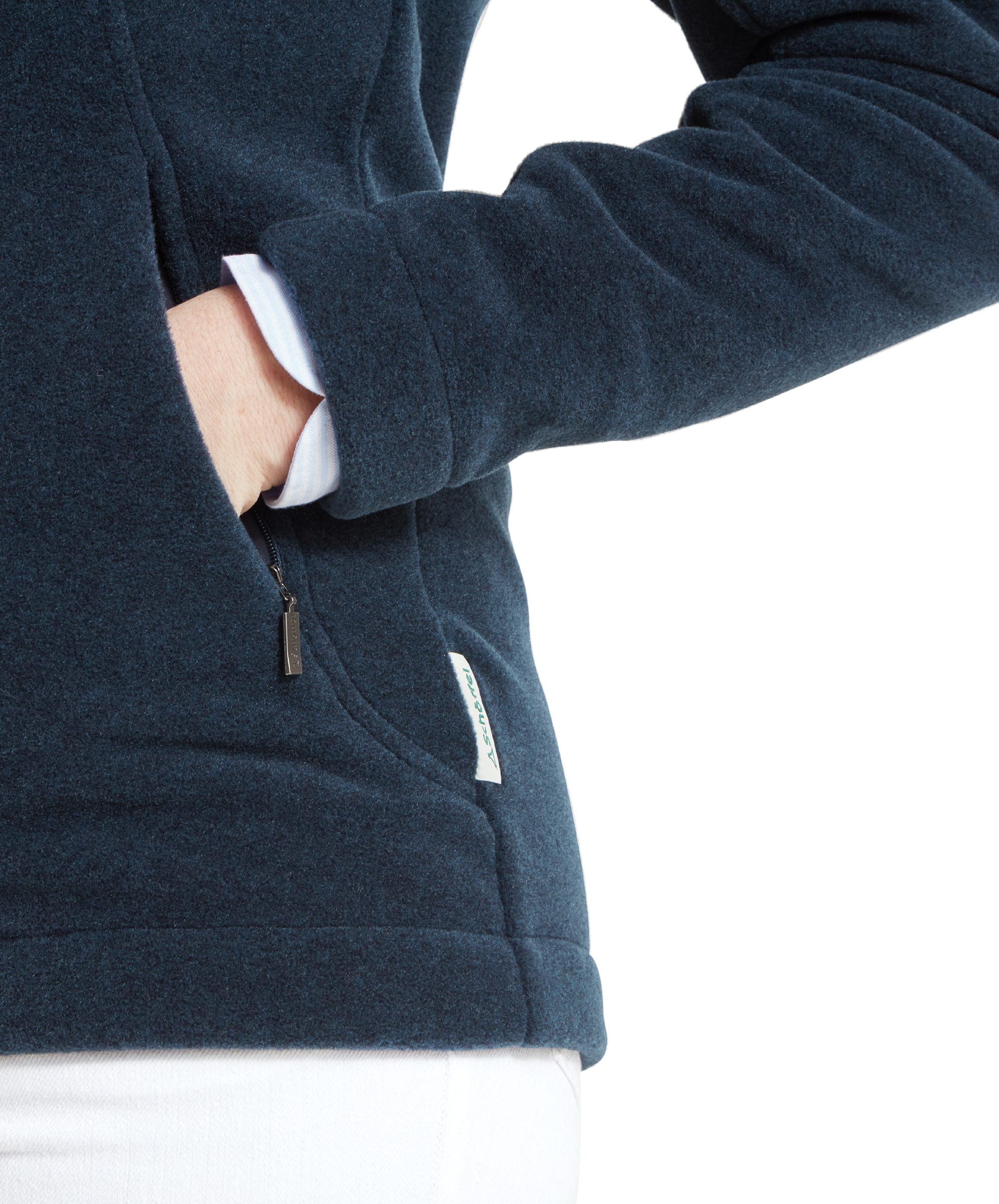 Close-up of the woman’s hand in the pocket of the Schöffel Burley Fleece Jacket for Women in Blue, showcasing the texture and details of the fabric, as well as the small Schöffel logo tag.