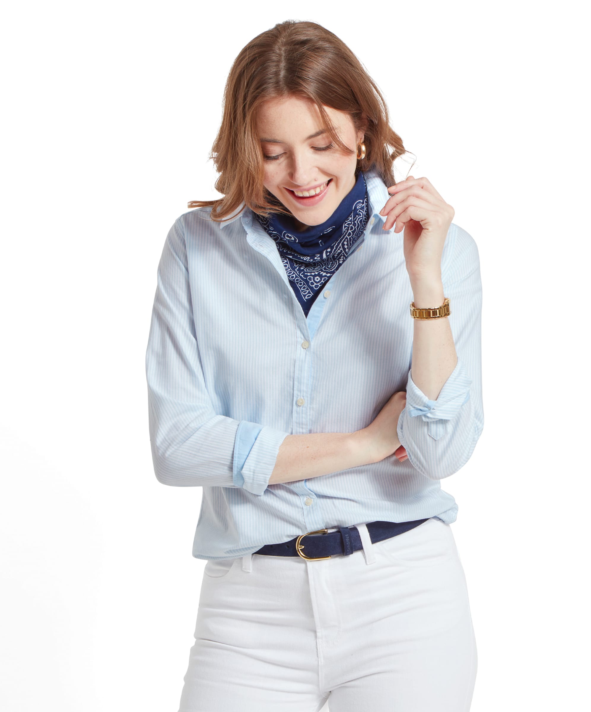 Woman wearing a Schöffel Cley Women's Soft Oxford Shirt for Womens in Blue, accessorised with a blue bandana and a gold watch, smiling and looking down.