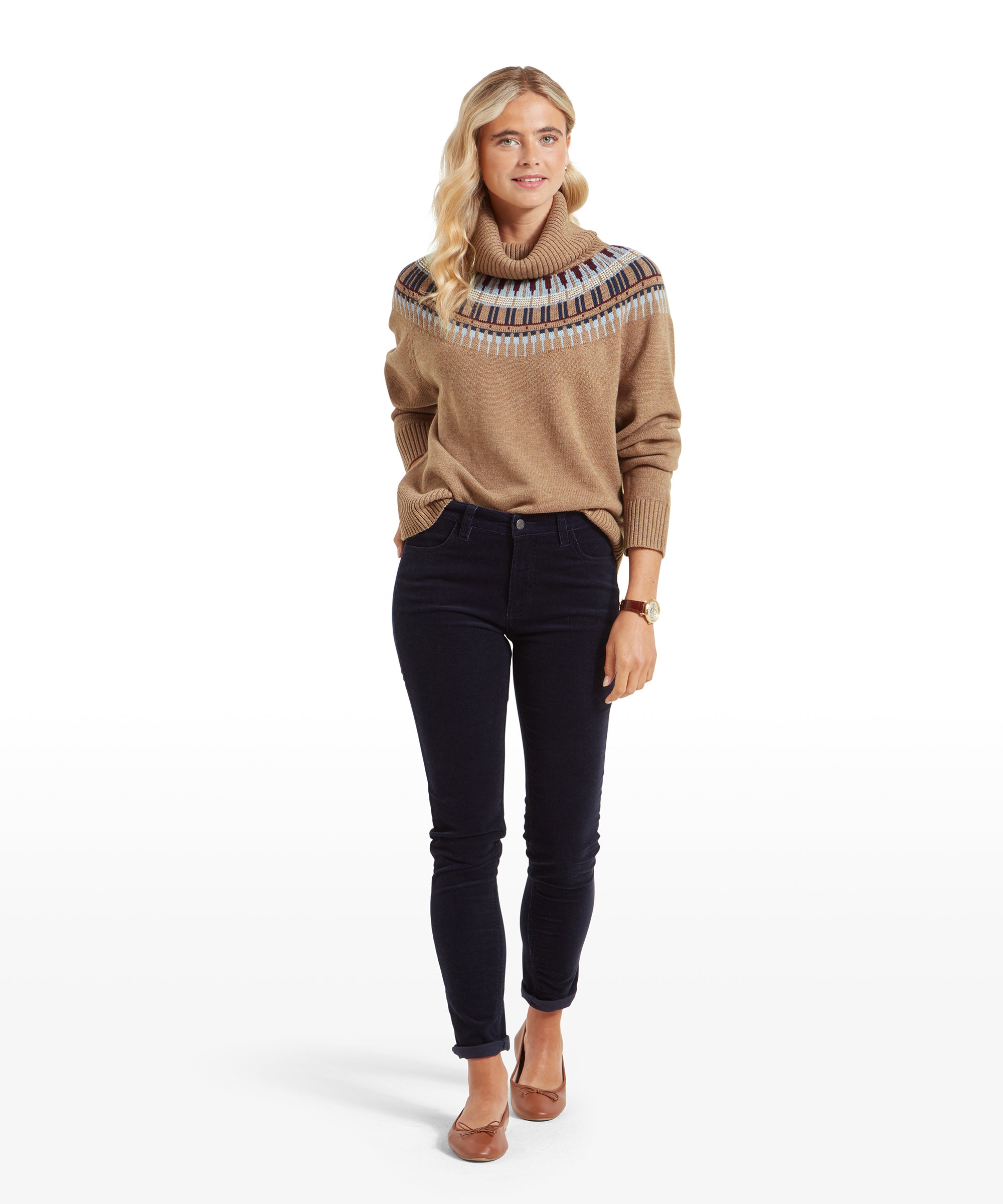 A full-body view of a woman wearing a beige sweater with a patterned yoke and Schöffel Clover Cord Jean for Womens in Navy. She is standing with her hands in her pockets, paired with brown flat shoes.